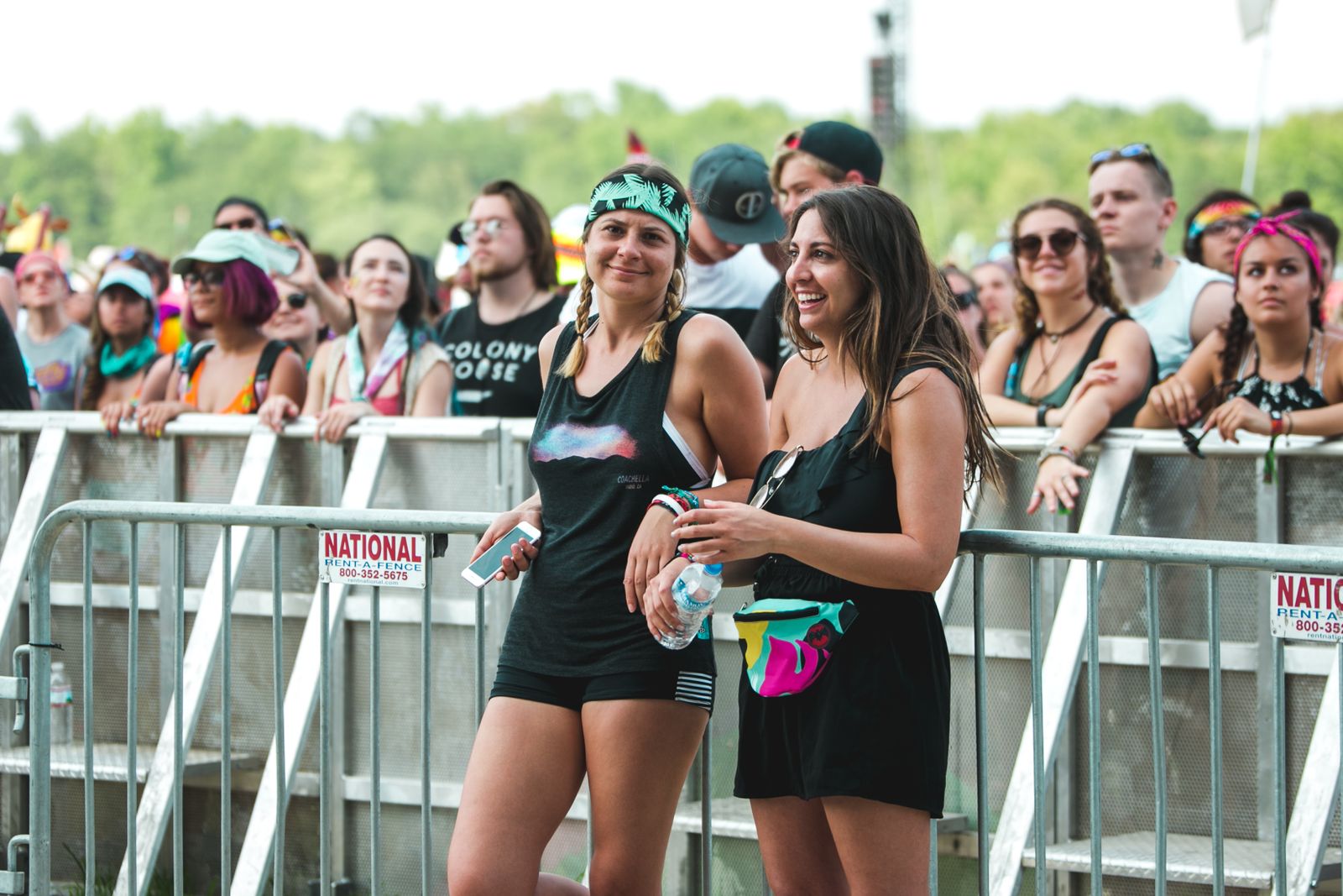 A crowd of young people enjoying a lively outdoor music festival during the day.