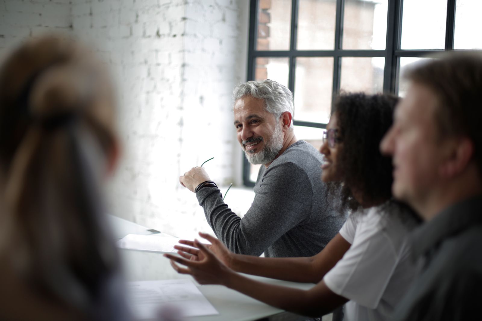 A diverse group of professionals engaging in a team meeting. Bright modern office setting.
