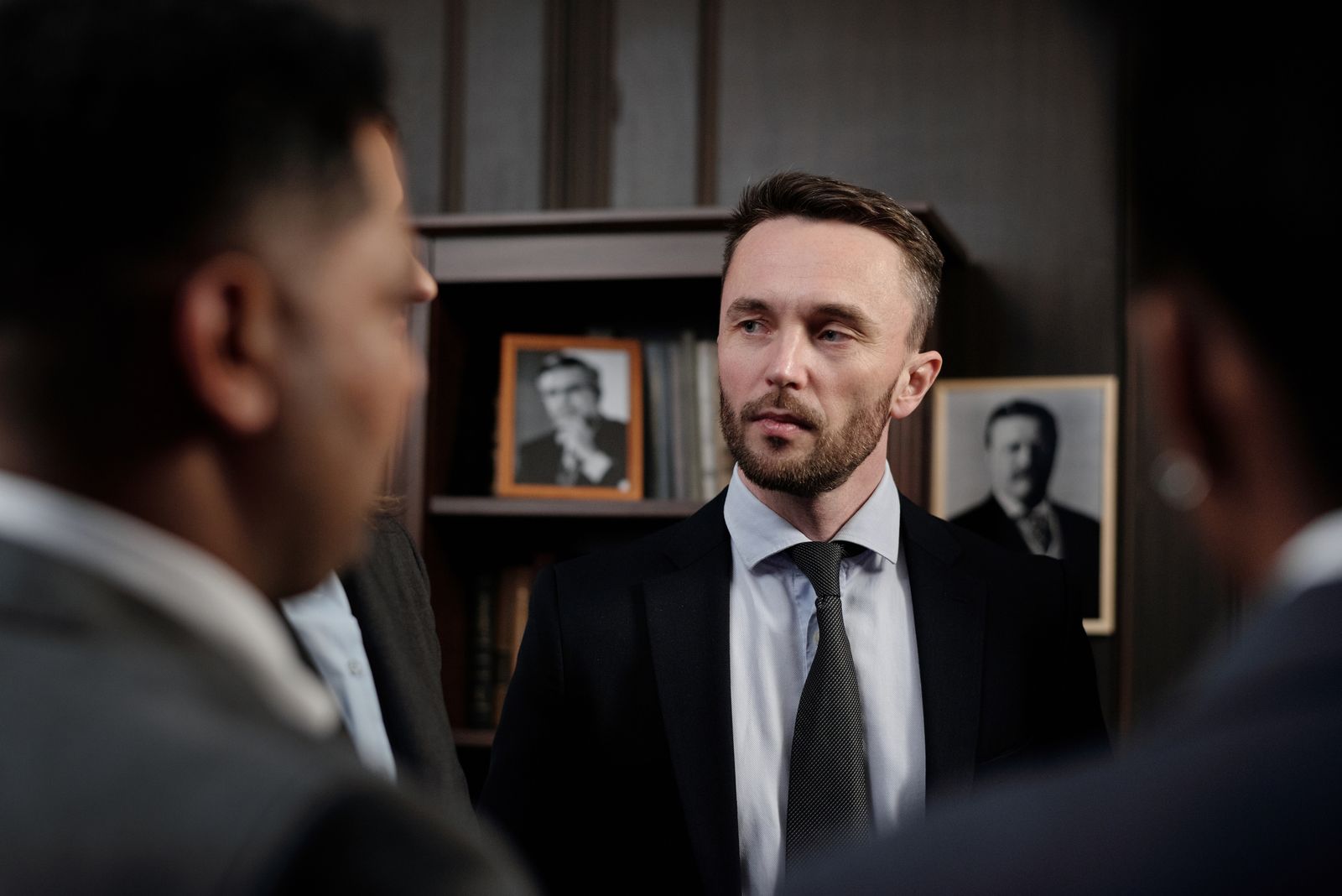 Group of men in suits having a serious business discussion in a professional setting.