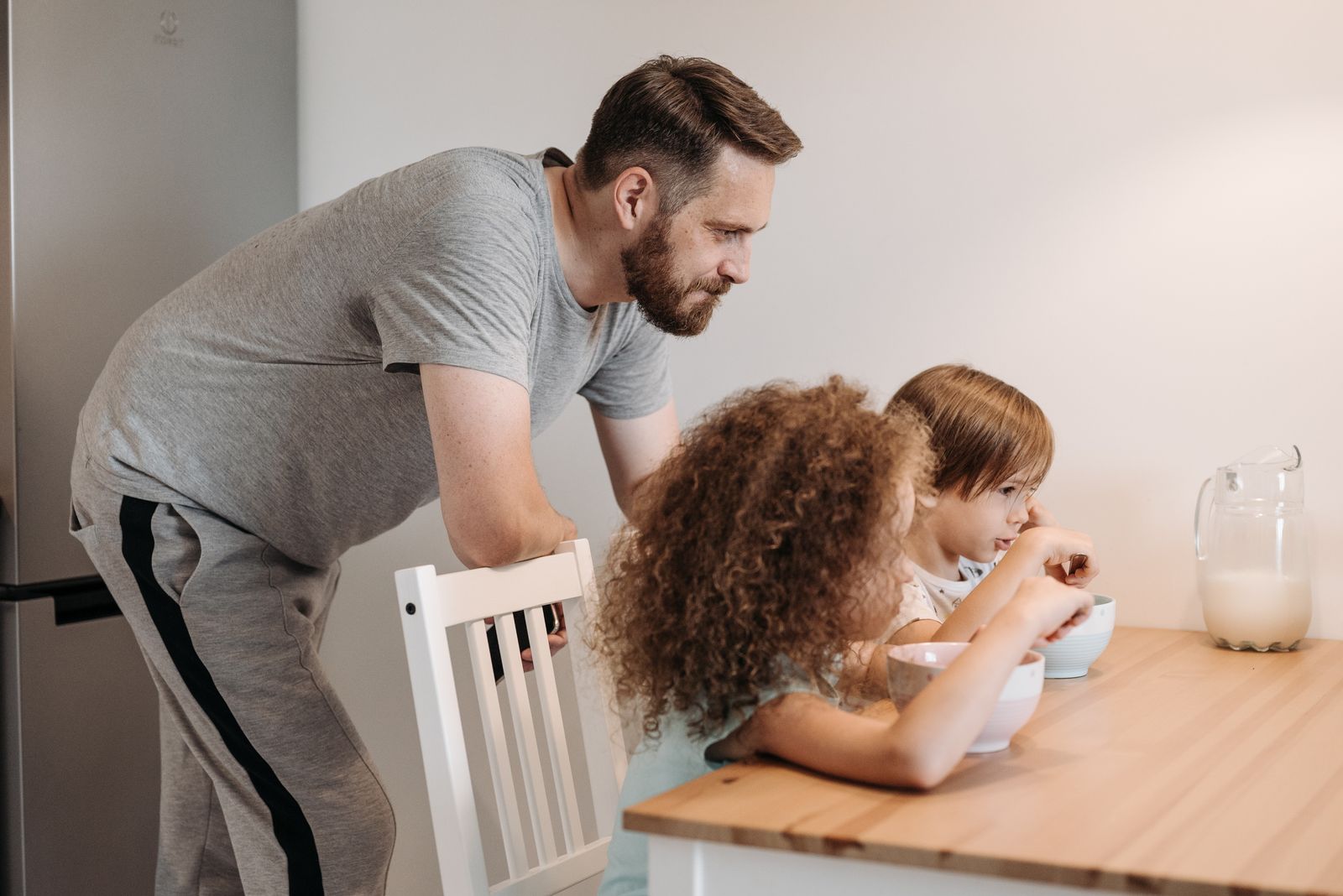 A father and children enjoying breakfast together indoors, creating a warm family bond.