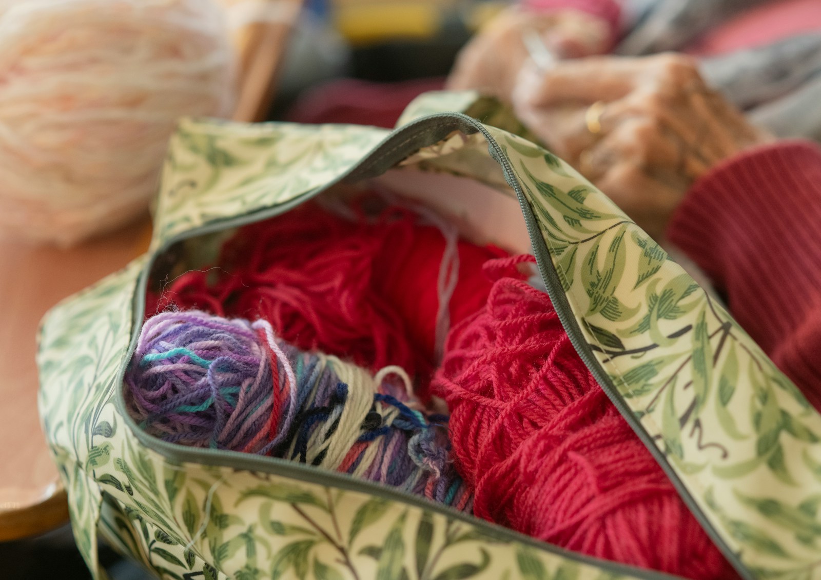 Bag filled with colorful yarn and knitting supplies