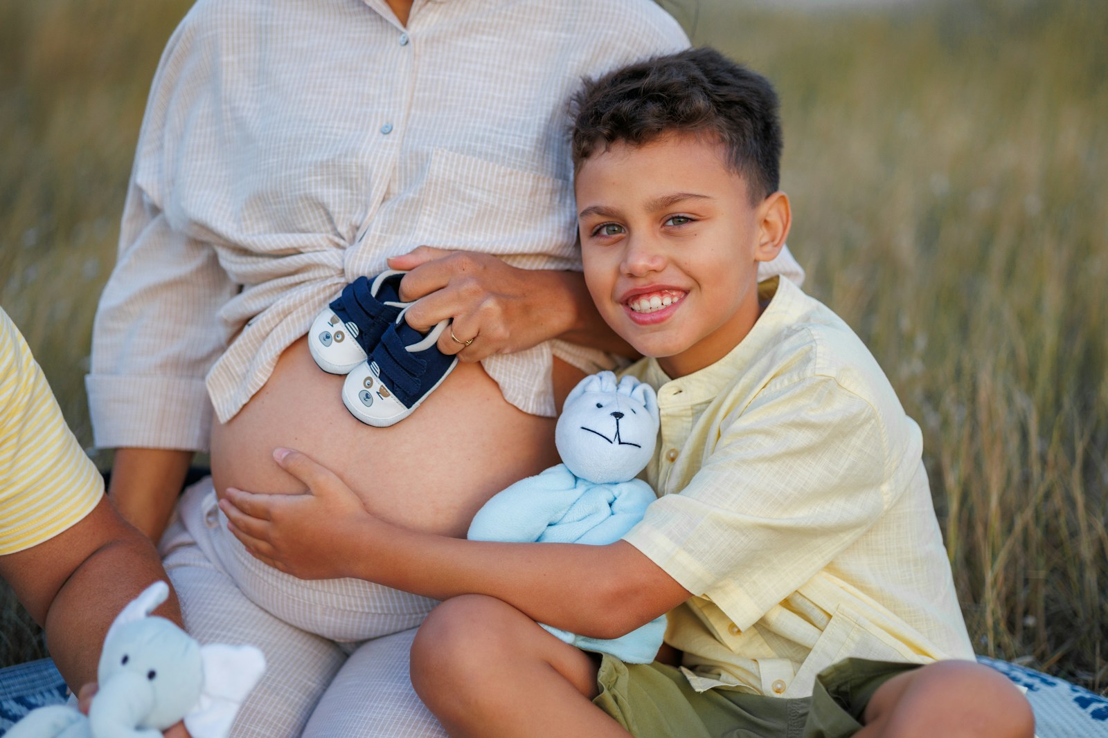 A pregnant woman, son, and toys.