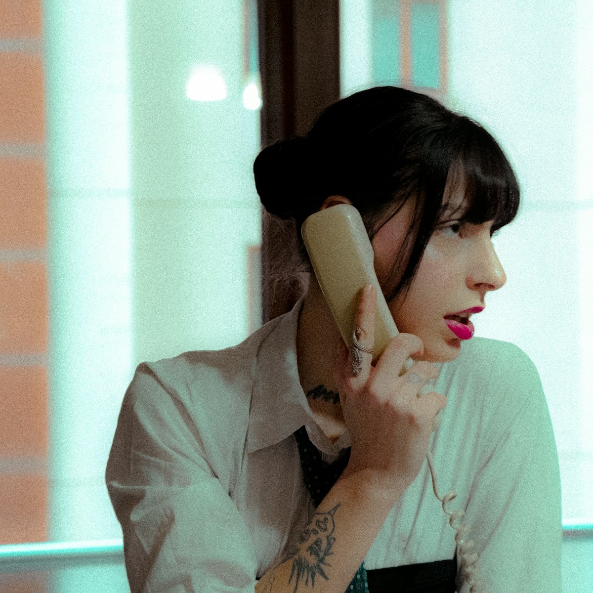 A woman in a white shirt talking on a cell phone