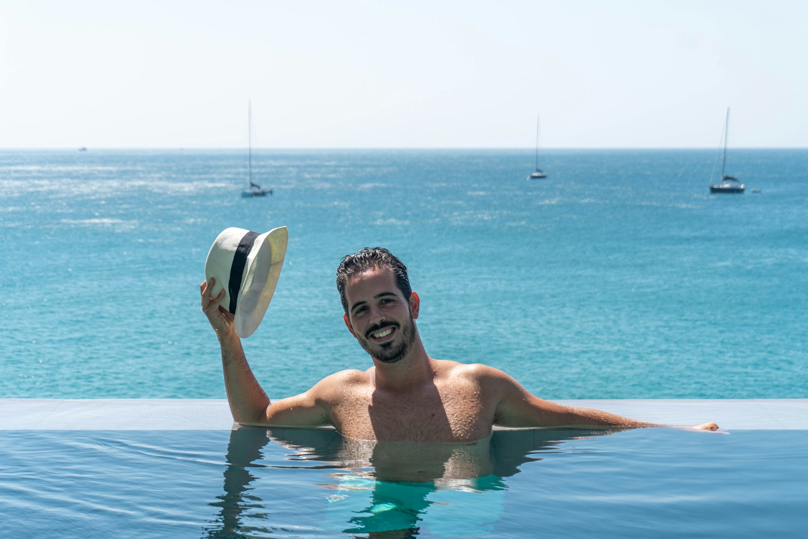 A man in a swimming pool with a hat on his head