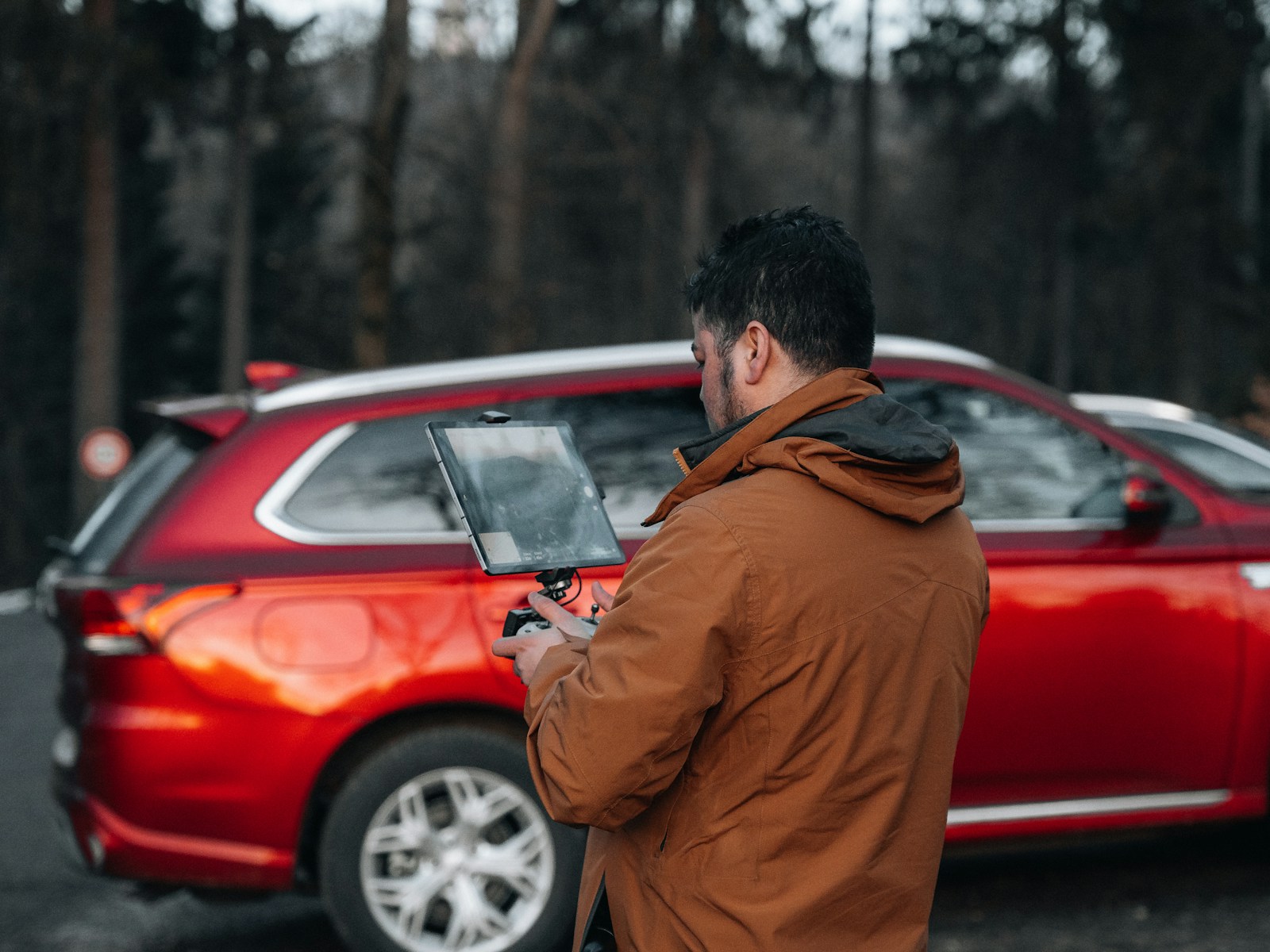 a man standing in front of a red car