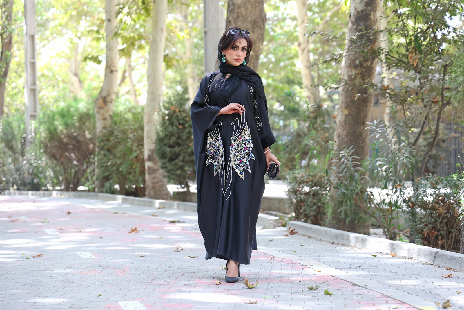 A woman in a black abaya walks outdoors