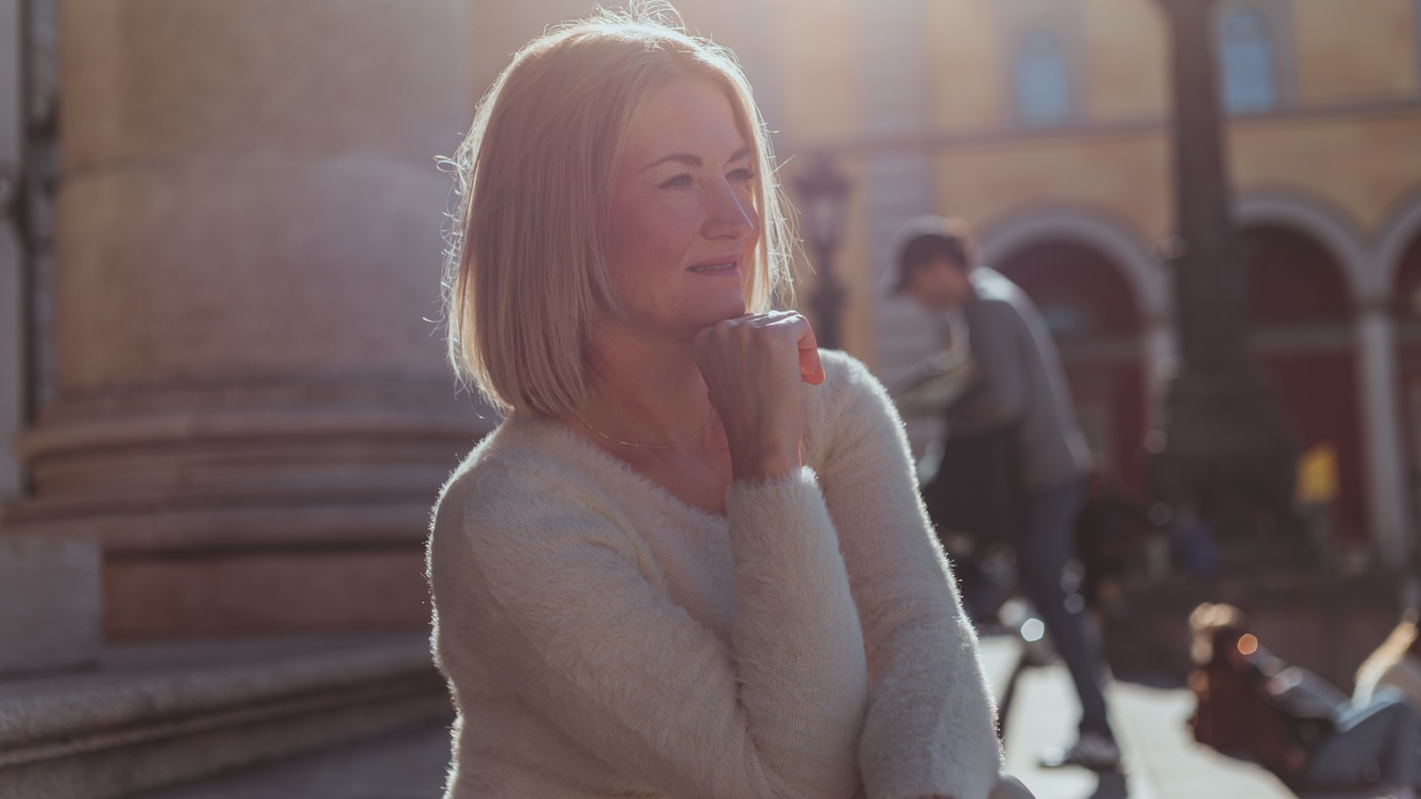 A woman standing on a sidewalk talking on a cell phone