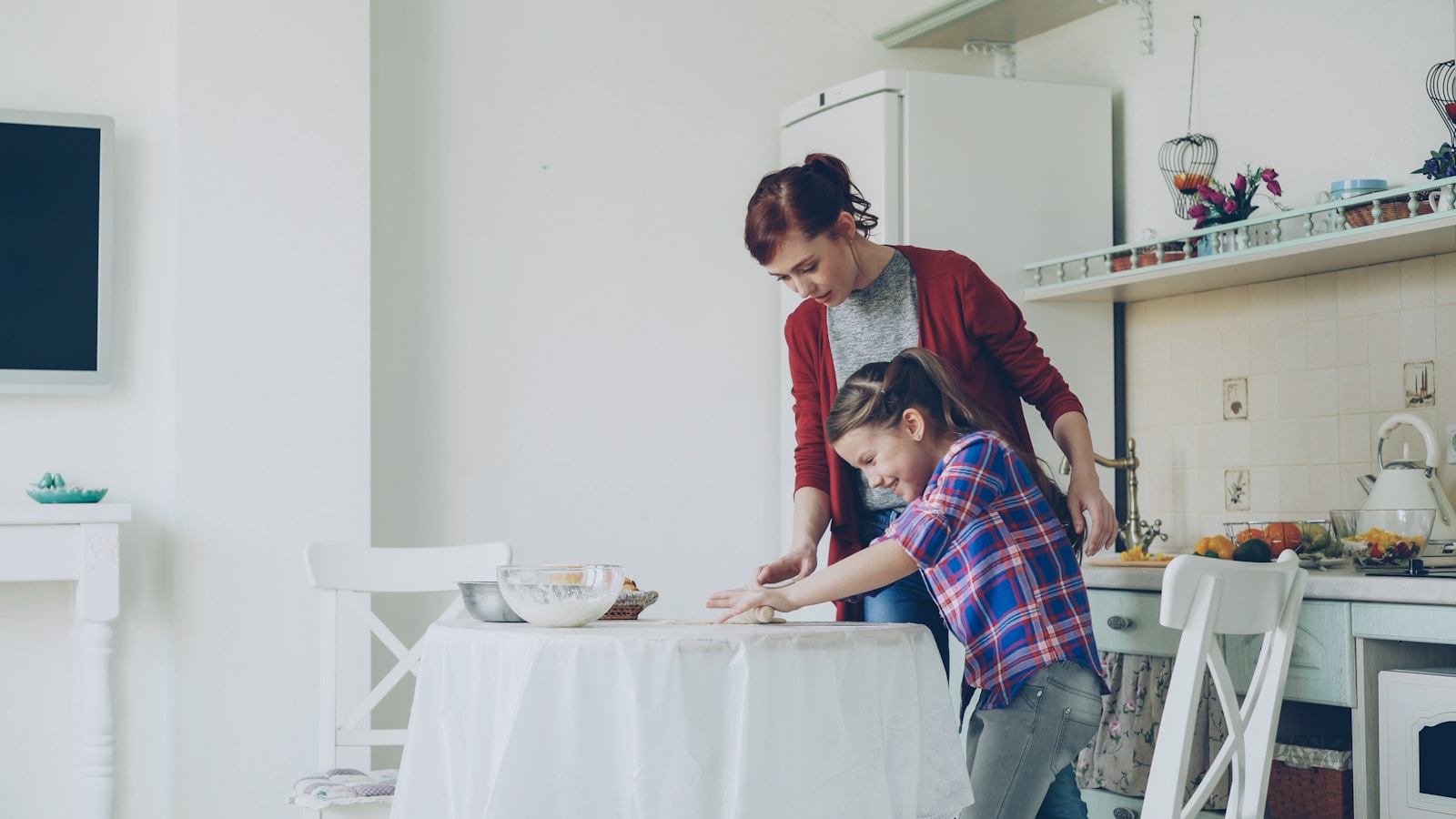 Mother and daughter cook together in a kitchen.