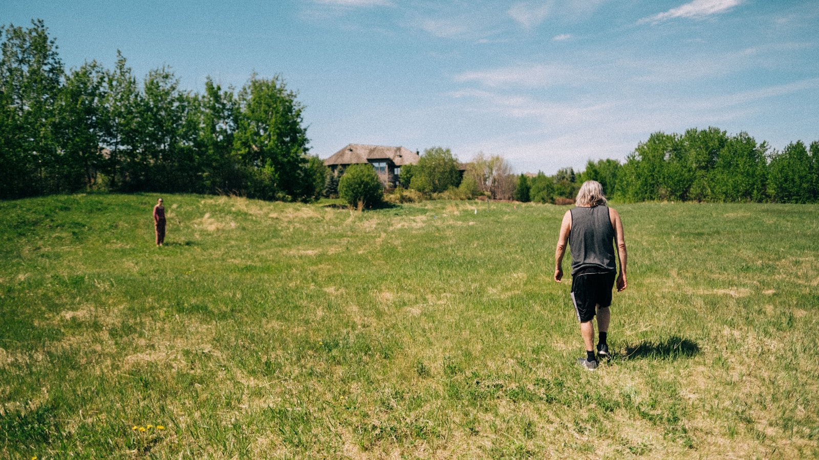 a man walking across a lush green field