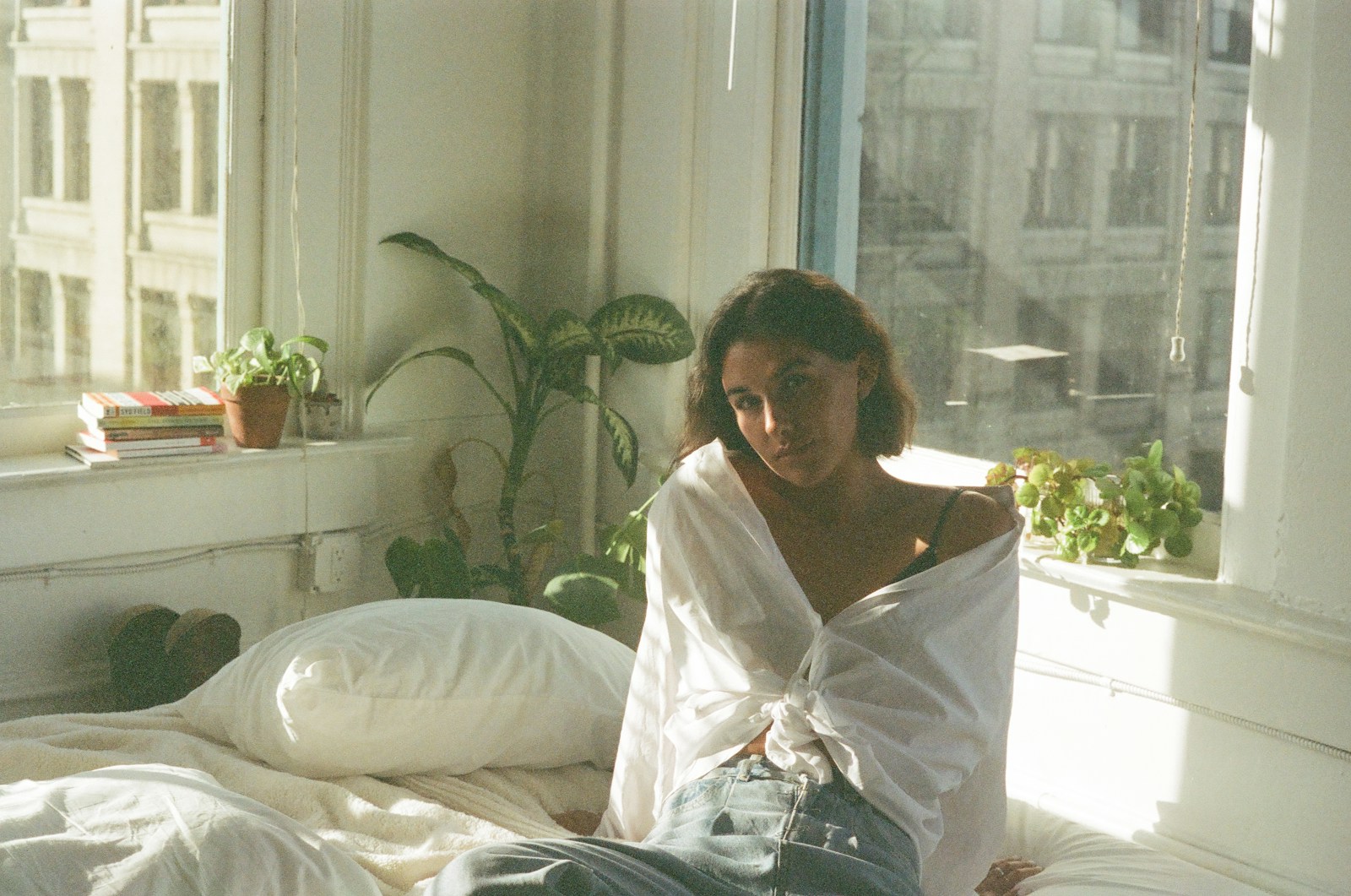 a woman sitting on a bed in a room