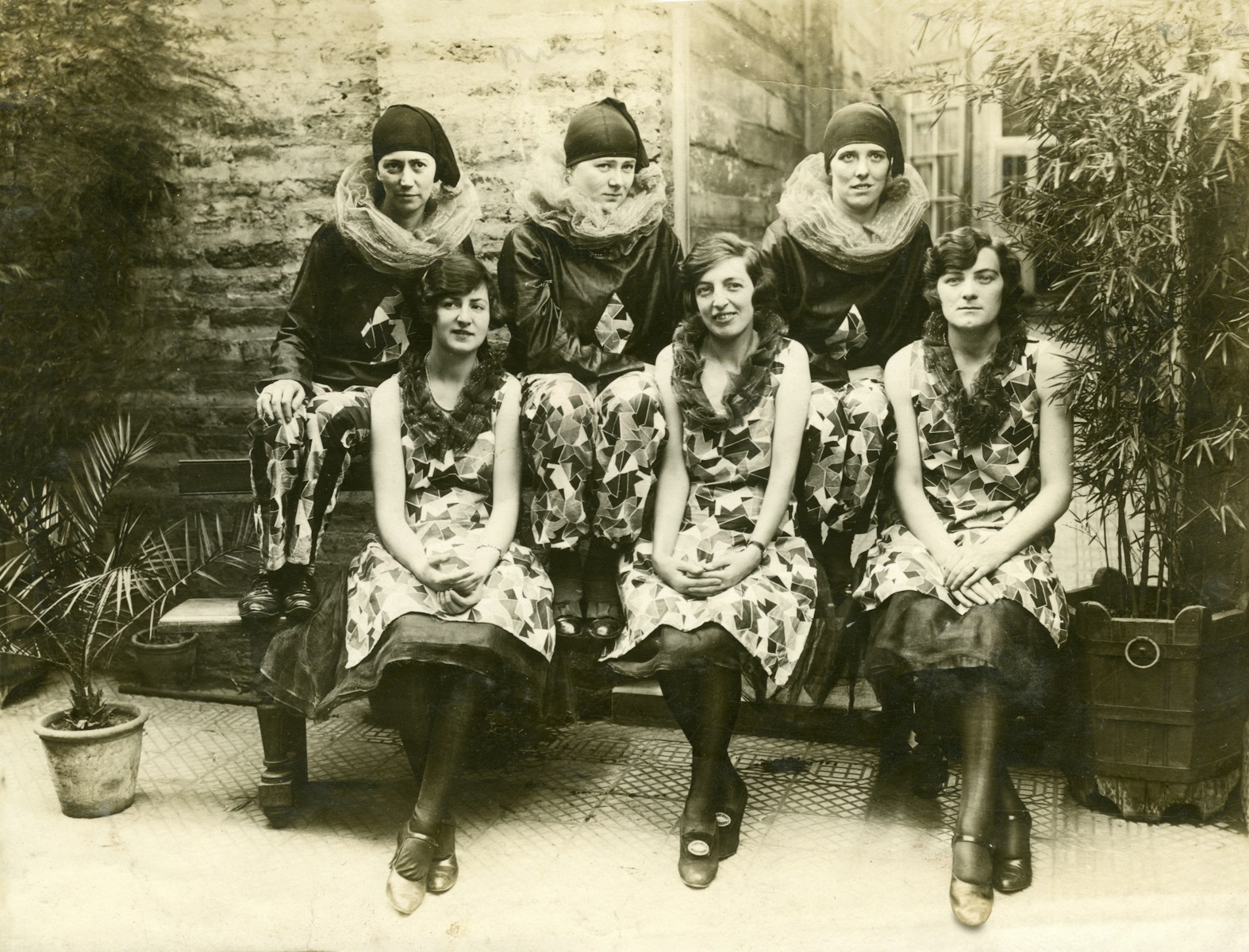 grayscale photo of 4 women sitting on bench