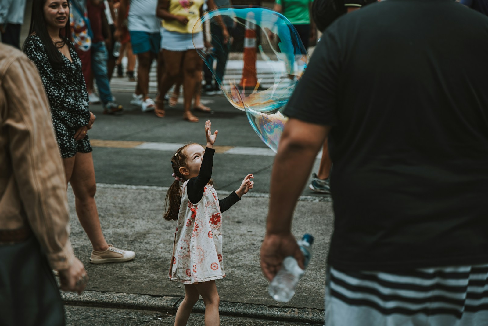 a little girl in a white dress playing with a kite