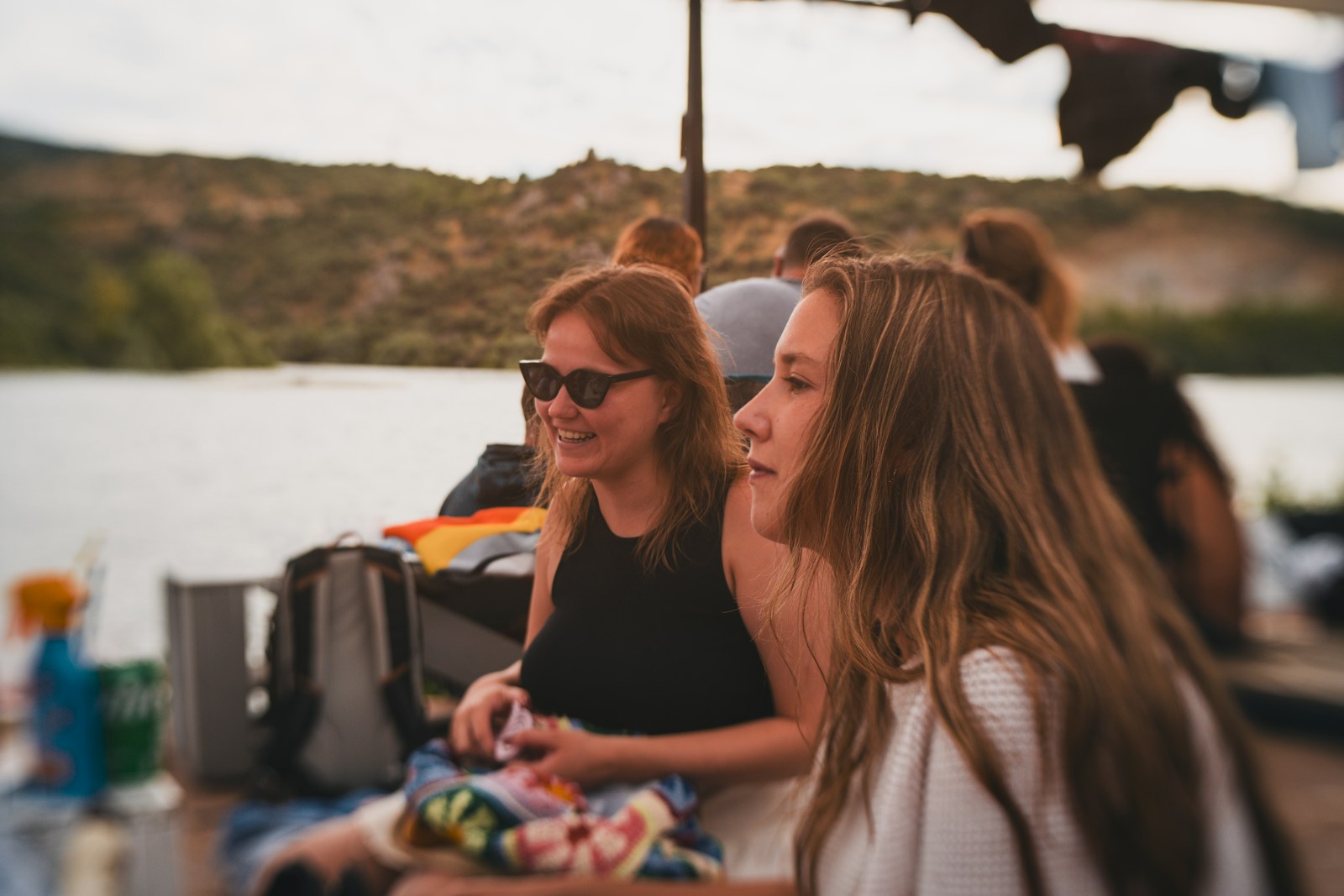 A group of women sitting at a table next to a lake