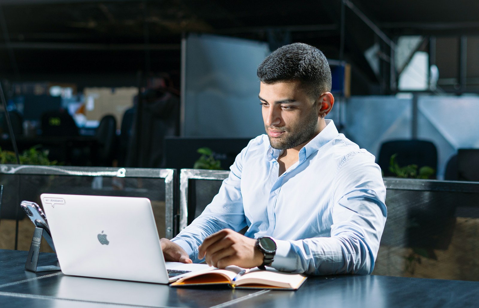 A man sitting at a table using a laptop computer