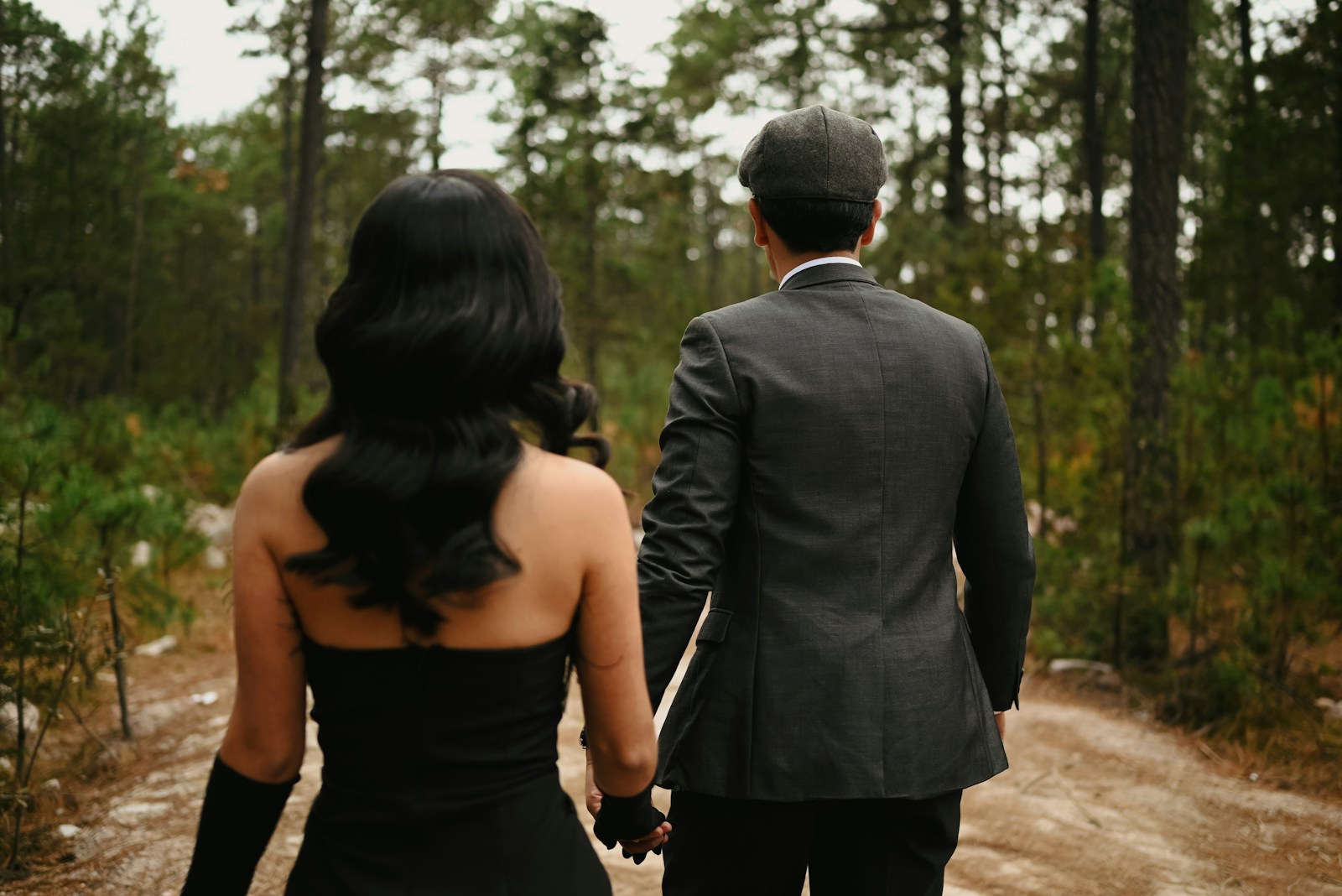 Couple walking hand-in-hand in a forest