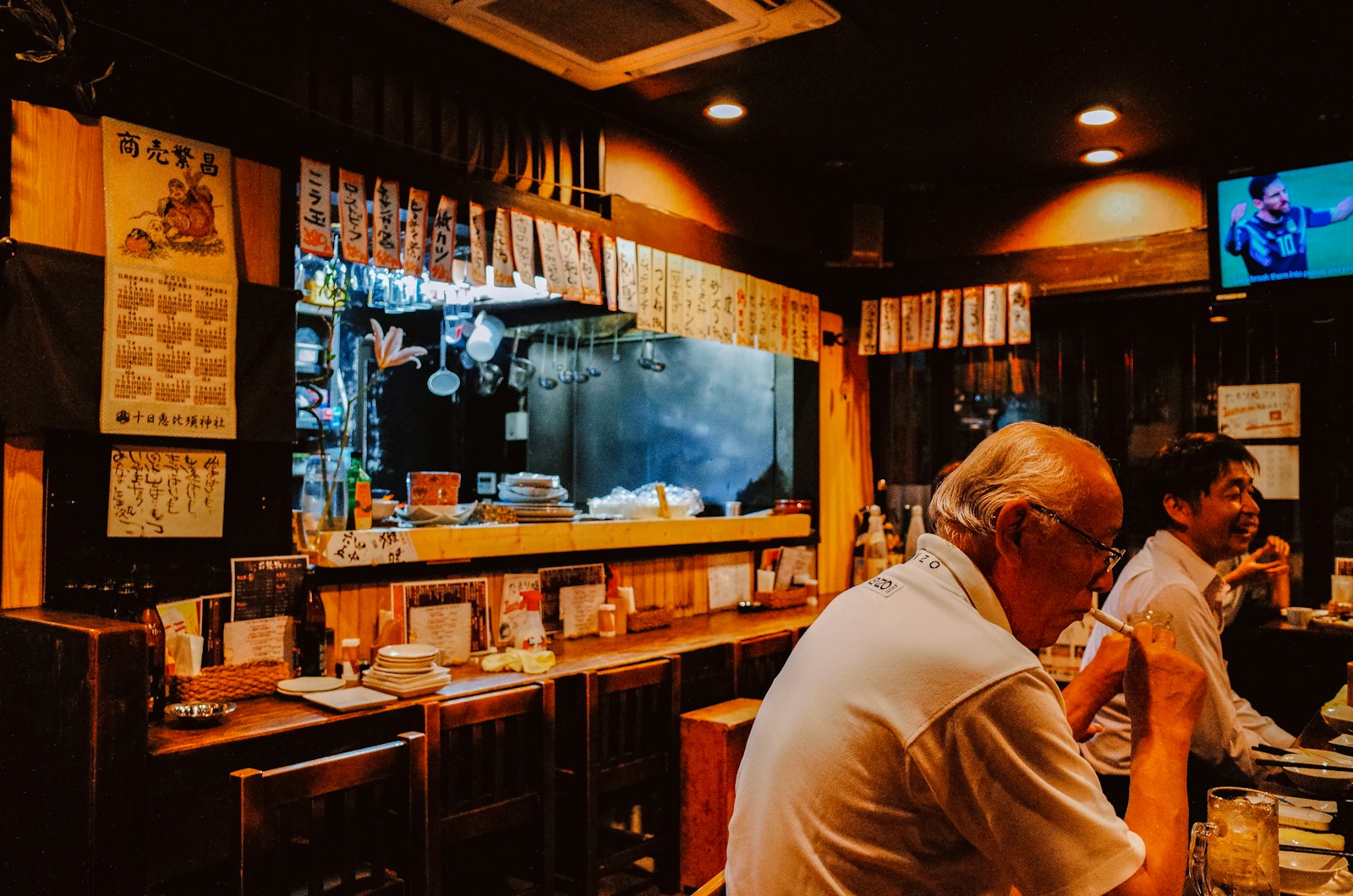 People sitting at a bar in a dimly lit restaurant.