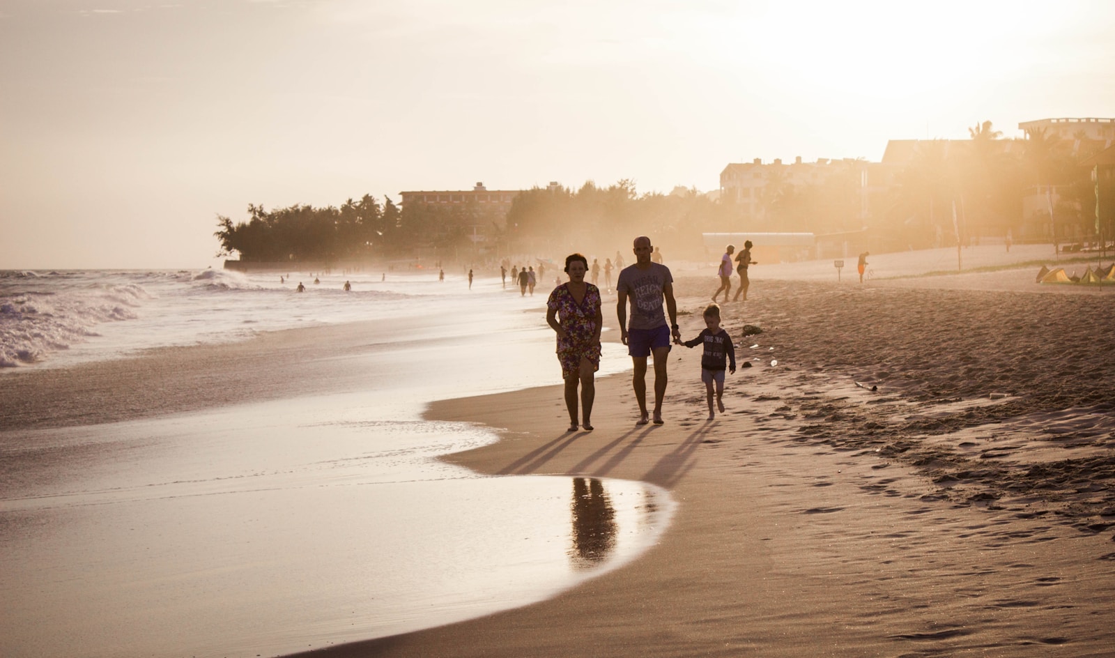 unknown persons walking on seashore