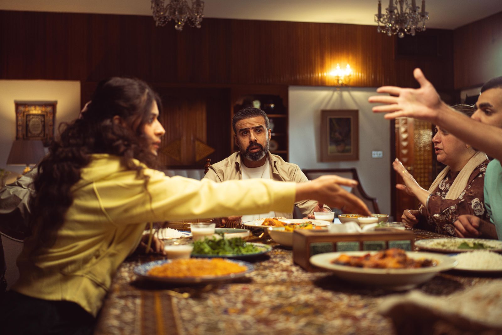 A lively family dinner with diverse group enjoying a meal and engaging in conversation.