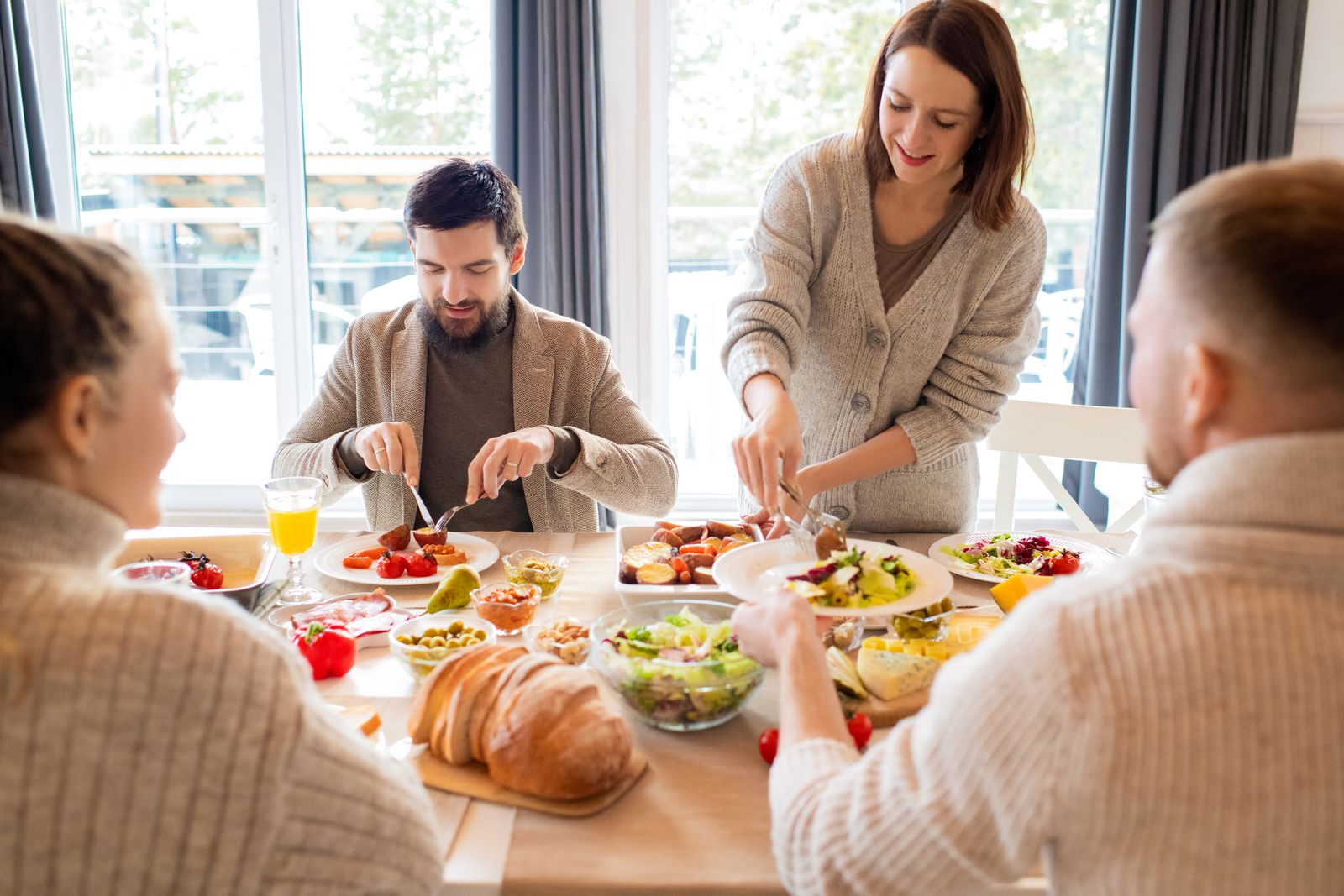 Four friends sharing a delightful meal indoors, highlighting friendship and togetherness.