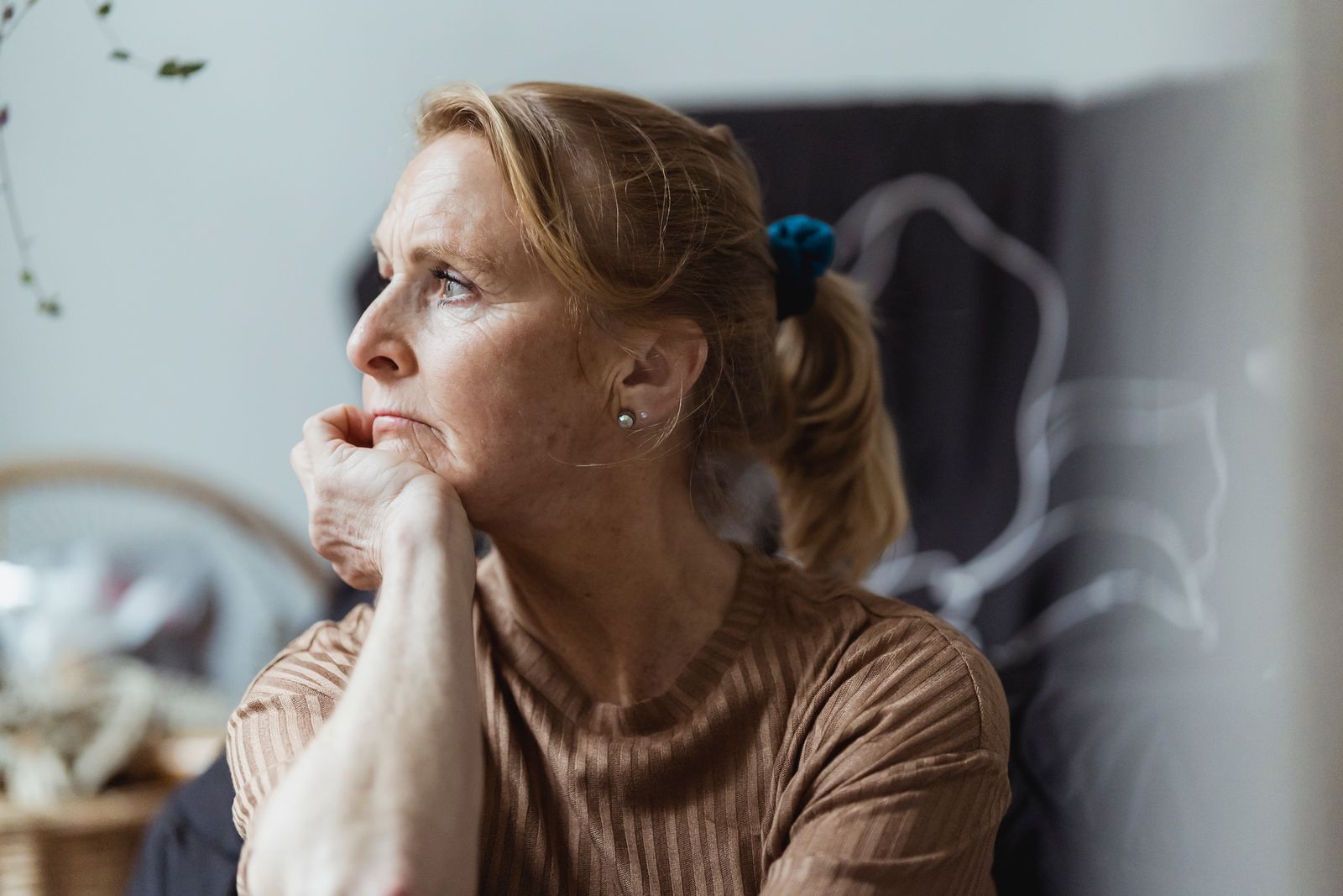 Senior woman with a thoughtful expression looking away in an indoor setting.