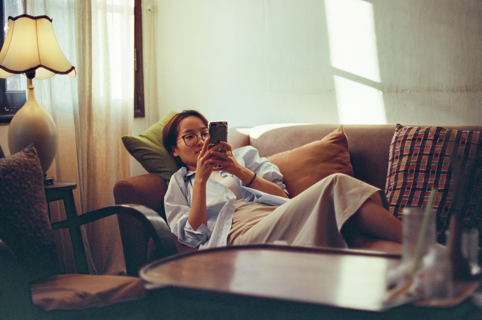 A woman sitting on a couch taking a picture of herself
