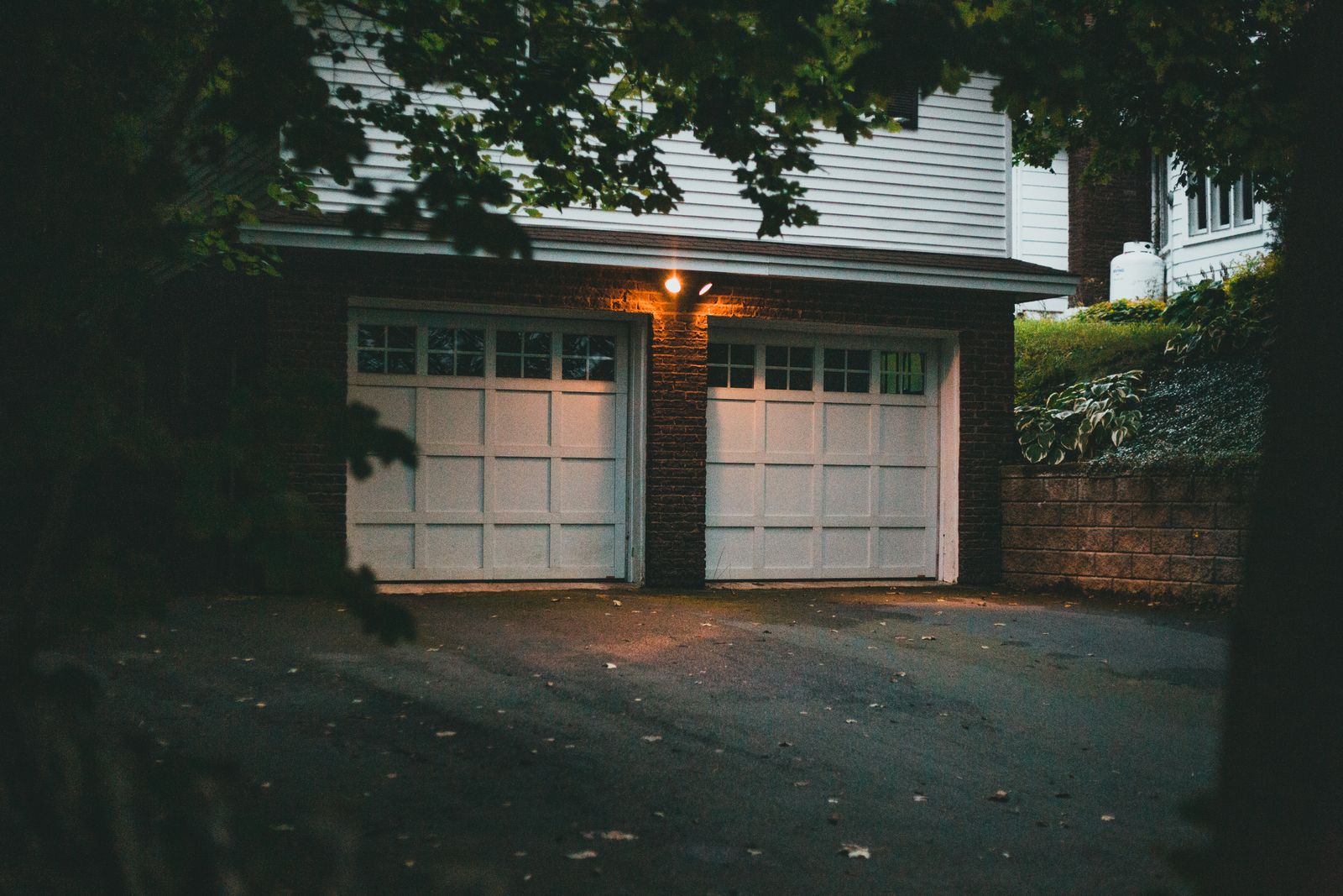 Warm evening view of a suburban garage with soft lighting creating a cozy atmosphere.