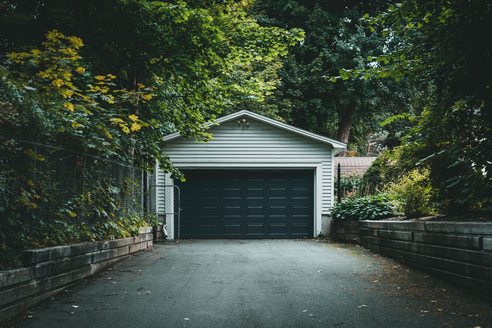 A scenic garage with lush greenery and a driveway, perfect for residential and nature-themed content.