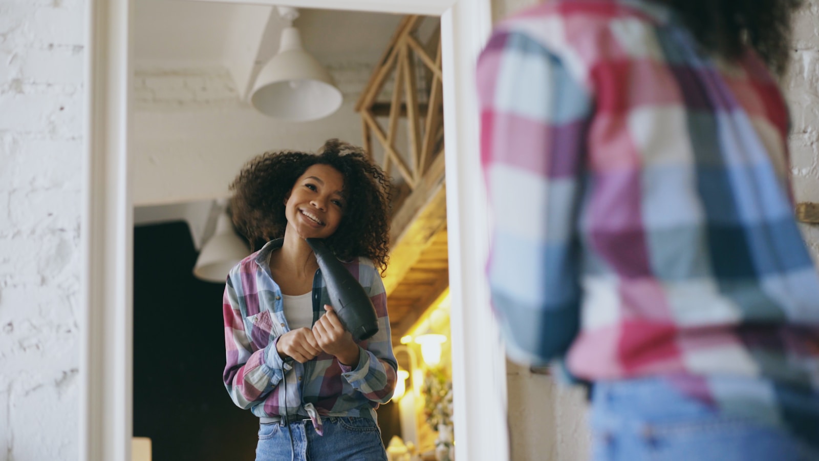Young woman smiling while drying her hair