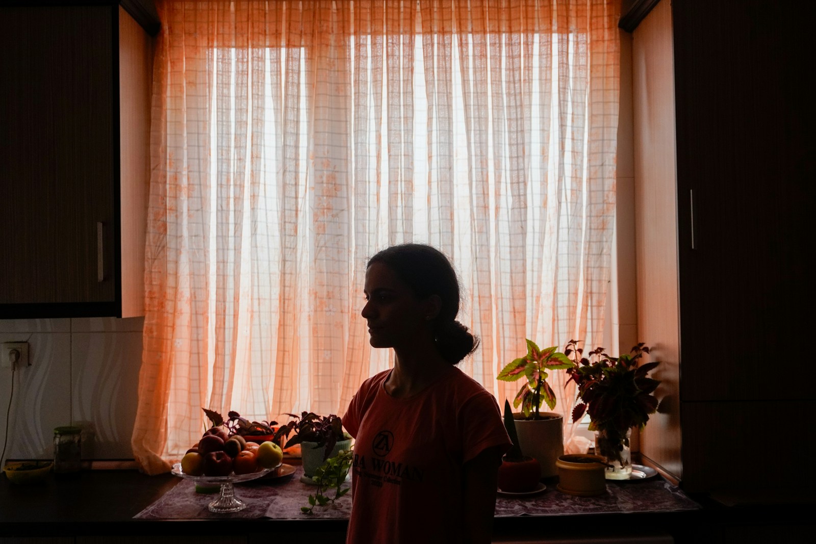 Silhouette of a woman in front of a sunlit window.