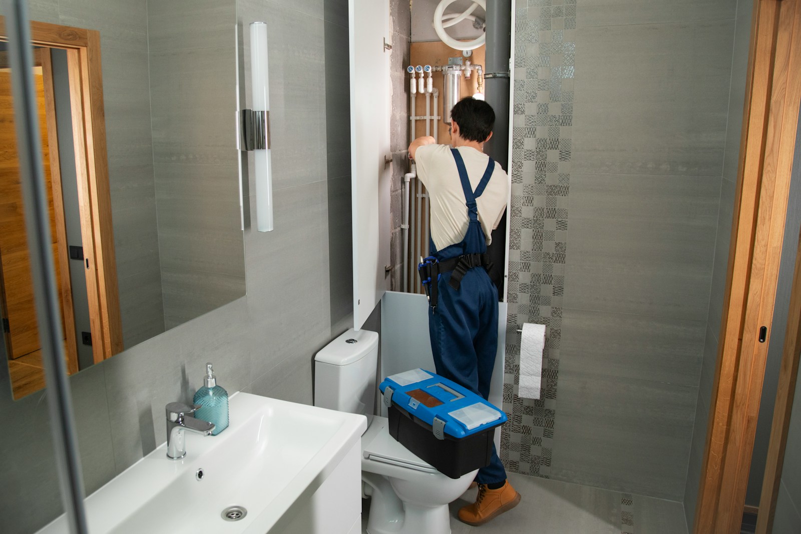A plumber repairs plumbing in a bathroom