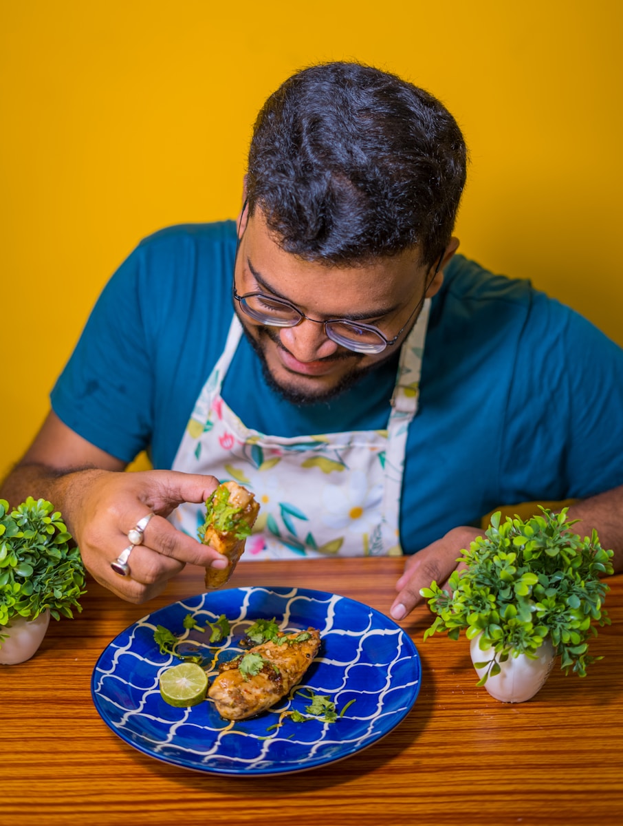 a man sitting at a table with a plate of food