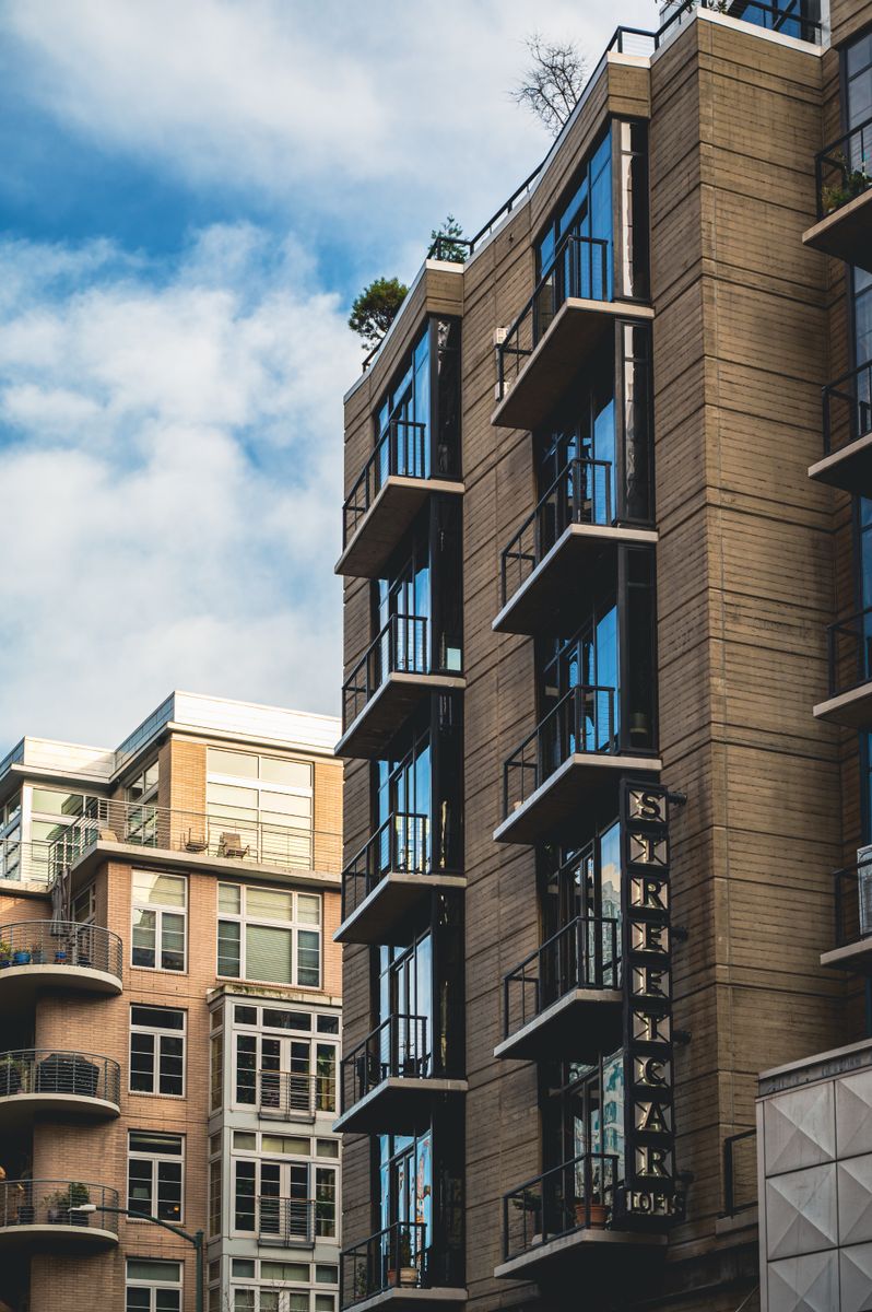 Contemporary apartment buildings featuring balconies, clear blue sky backdrop.