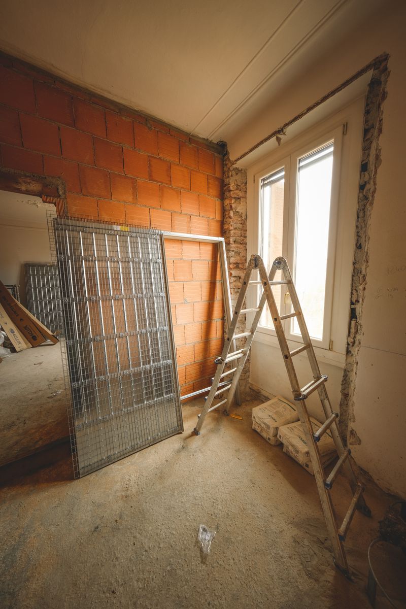 An indoor space showing ongoing refurbishment with ladders and construction materials.