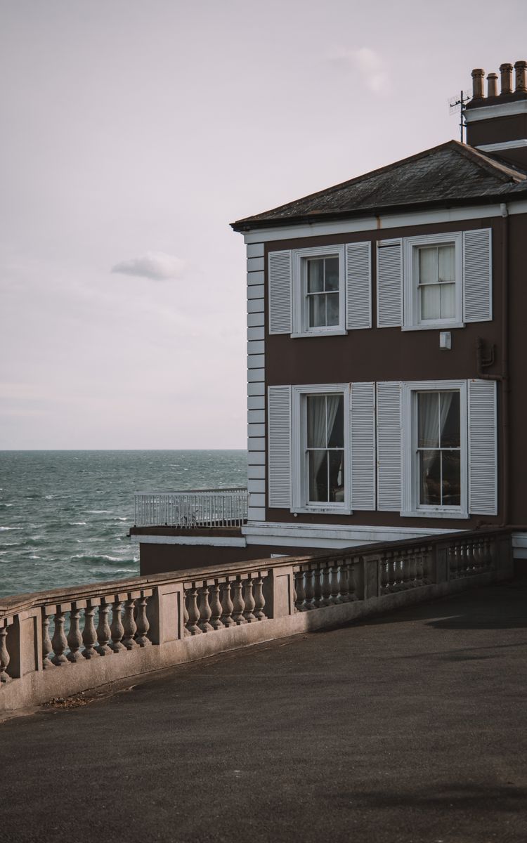 Elegant seaside house with shutters overlooking the ocean in Dublin, Ireland at twilight.