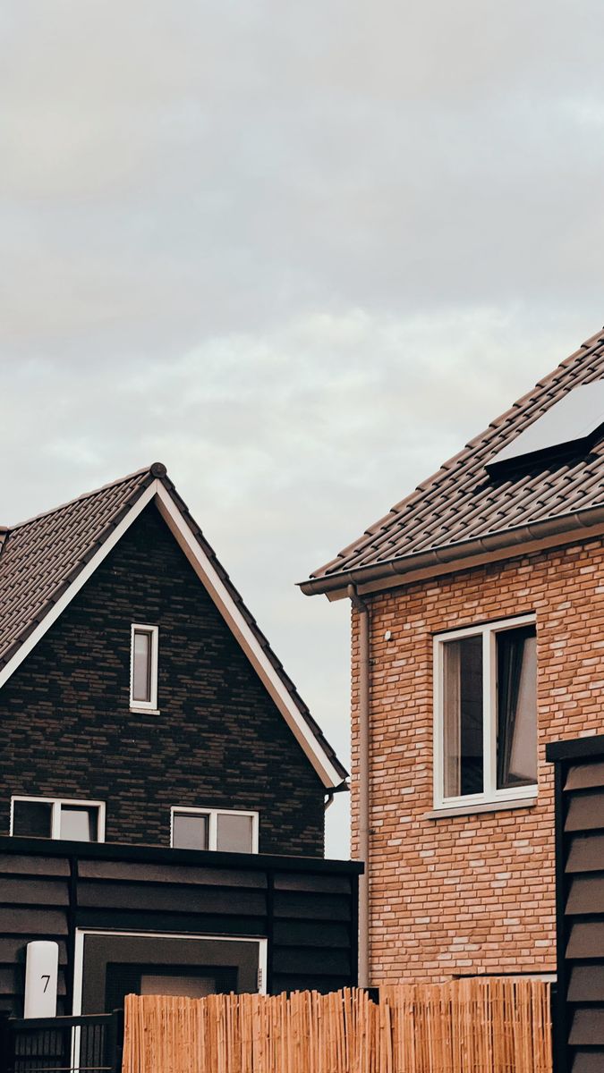 Close-up of modern homes with distinctive architecture under an overcast sky, showcasing residential design.