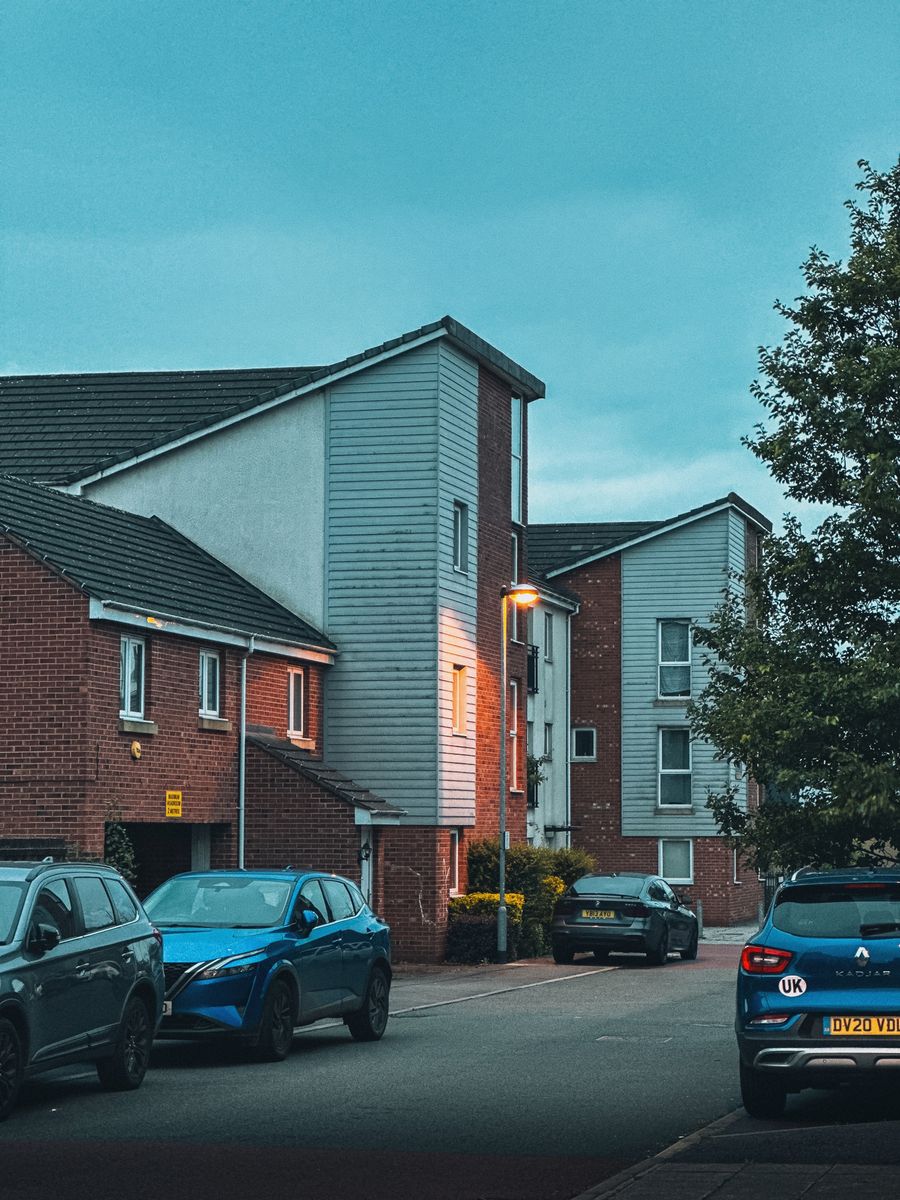 Evening view of a suburban residential area with parked cars lining the street.