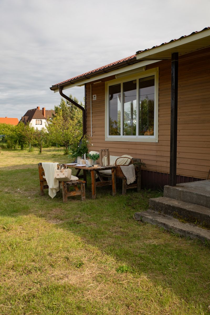 Charming outdoor dining by a wooden cottage, perfect for summer gatherings.