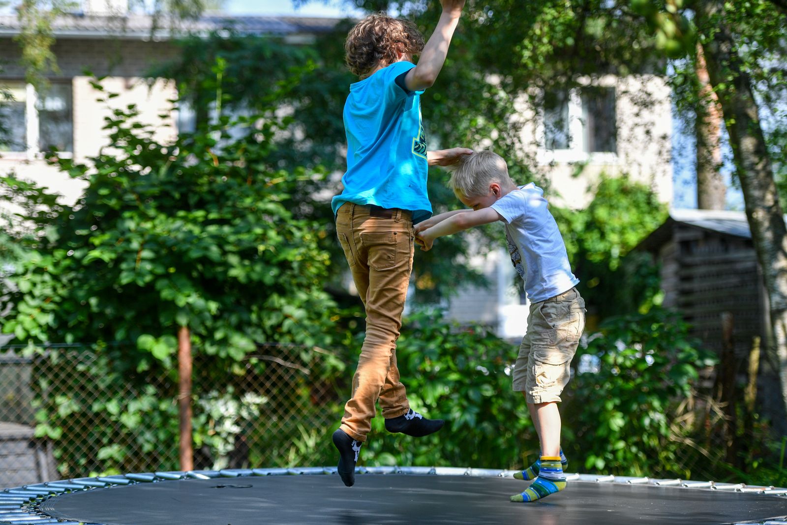 Two kids enjoying trampoline fun on a sunny day in Tallinn, Estonia.