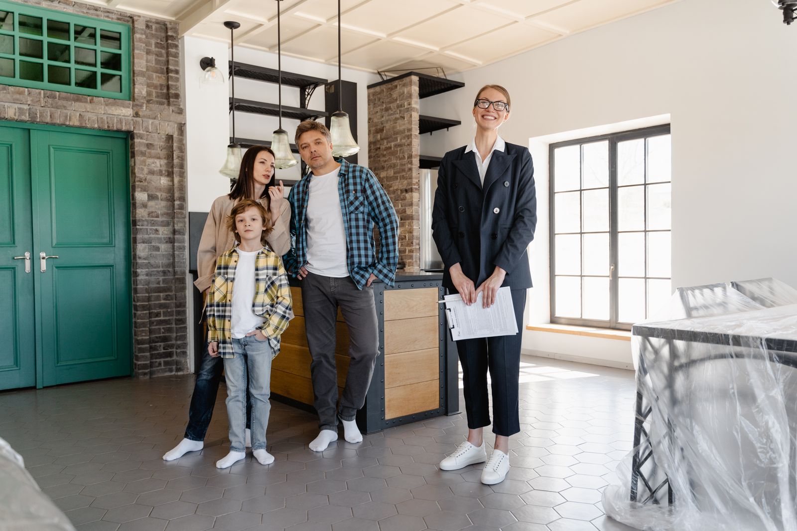 A family tours a modern home with a real estate agent, showcasing interior design.