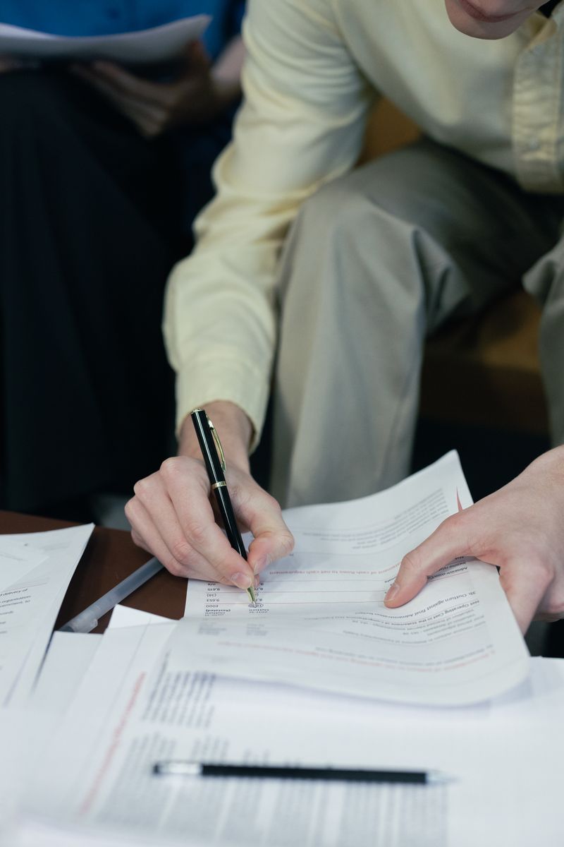 A focused close-up of a person signing essential paperwork, capturing the essence of business and documentation.