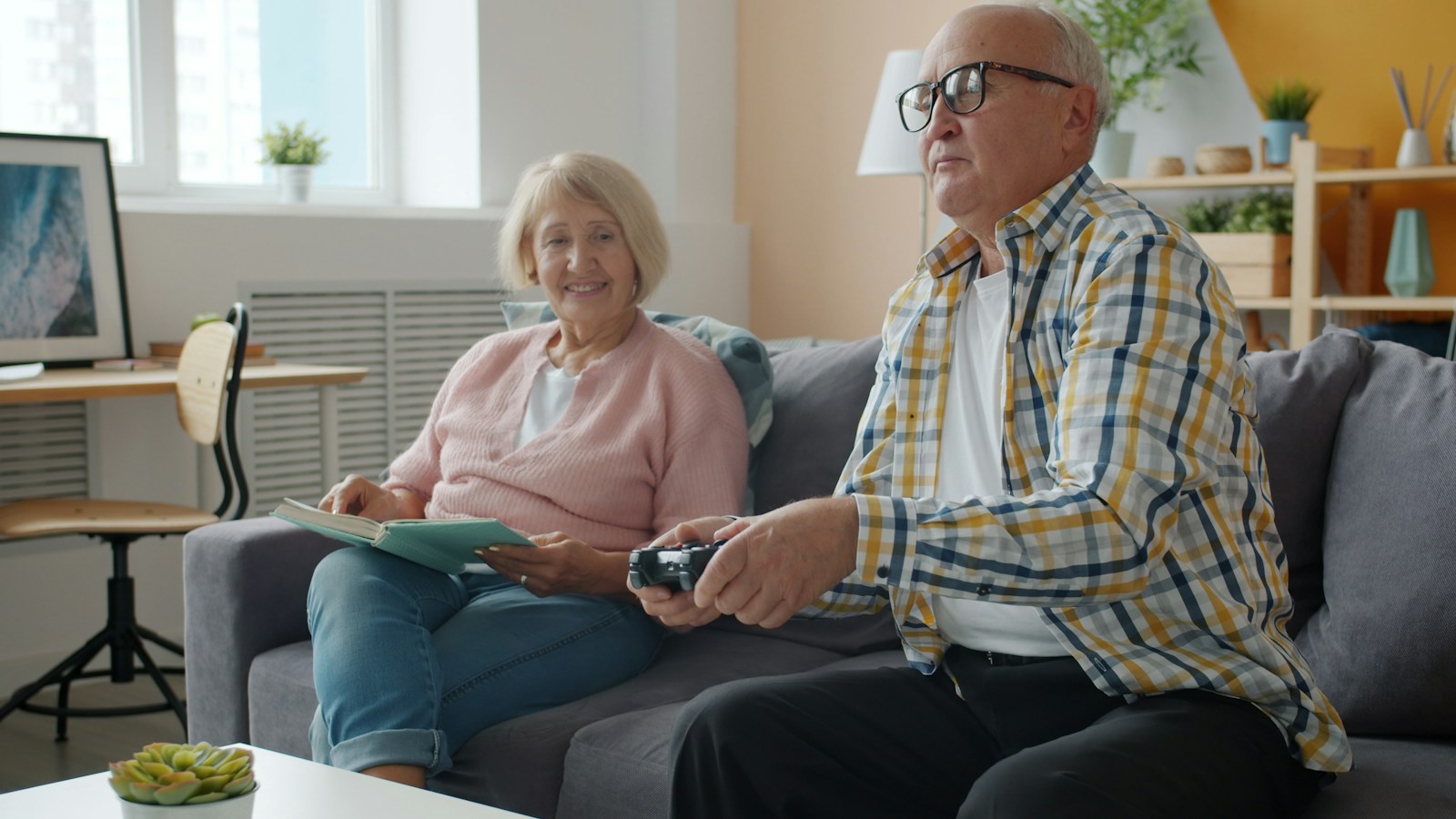 Elderly couple playing video games on the couch