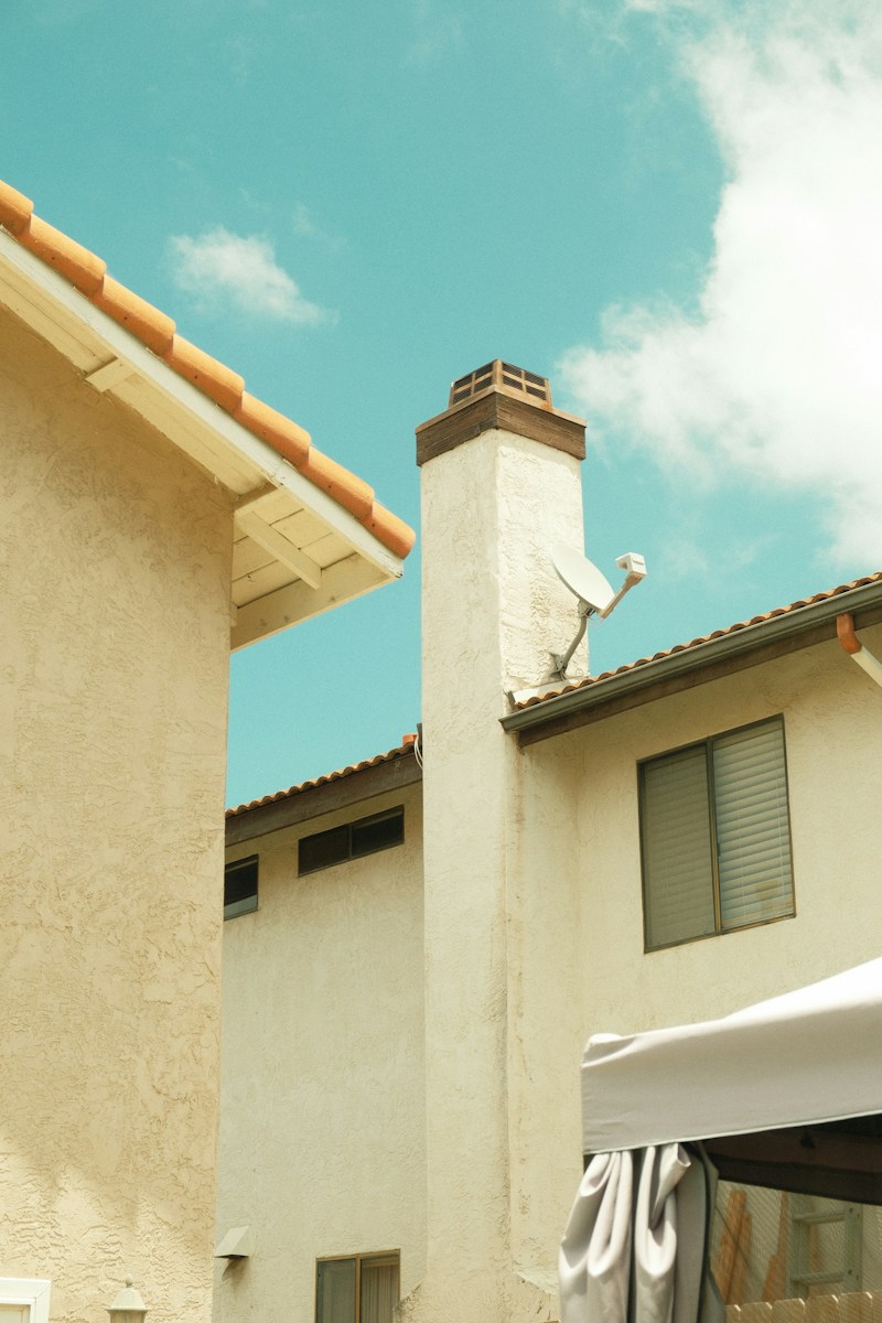Stucco houses with tiled roofs, chimney, and blue sky