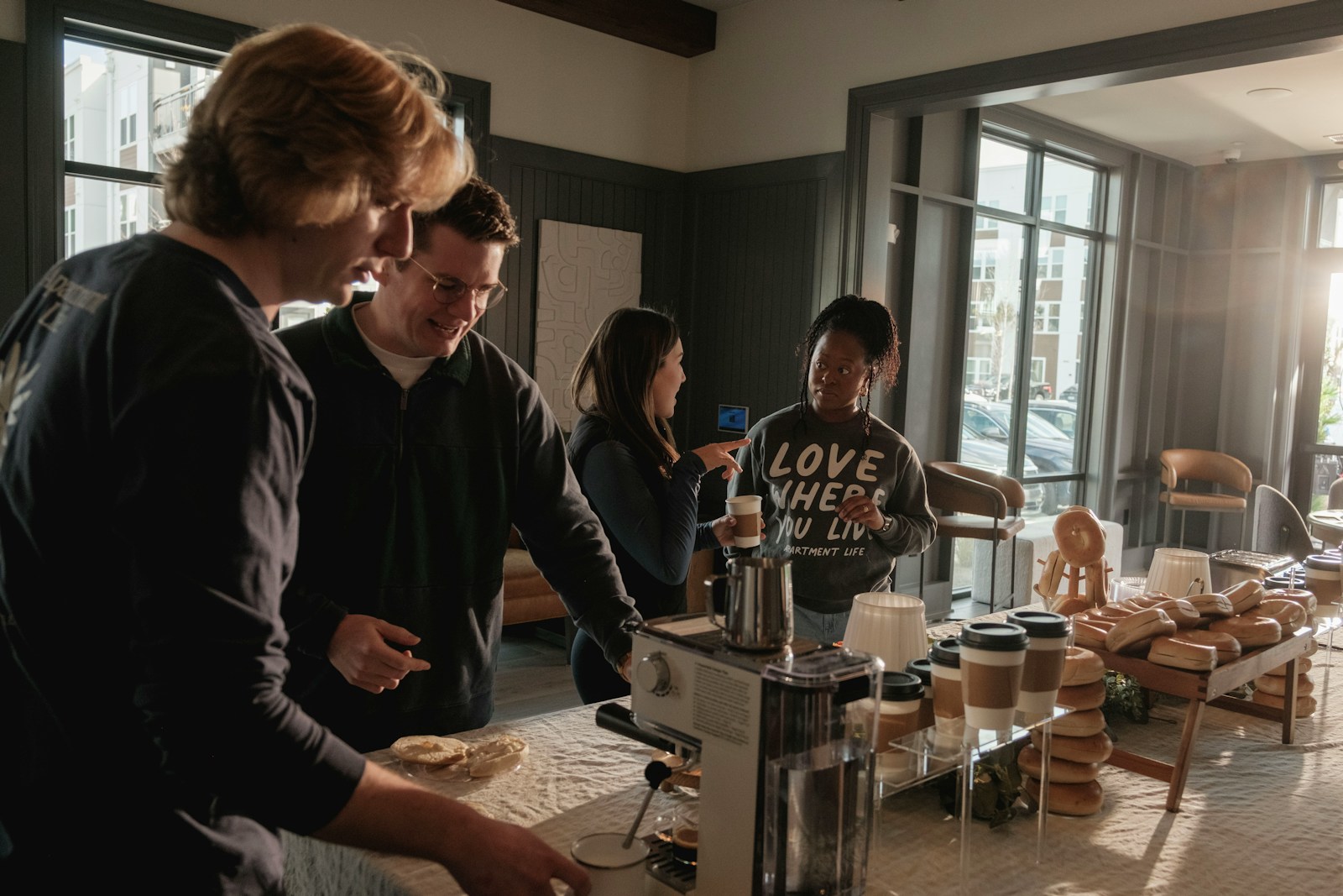 People gathered around a coffee machine in a kitchen