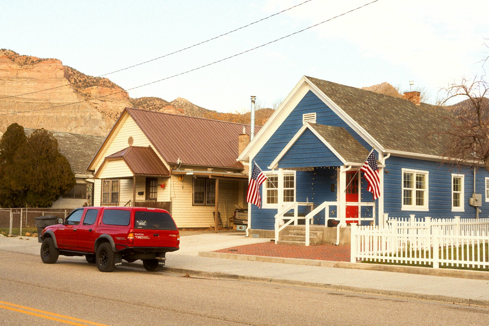 Red suv parked in front of blue and tan houses