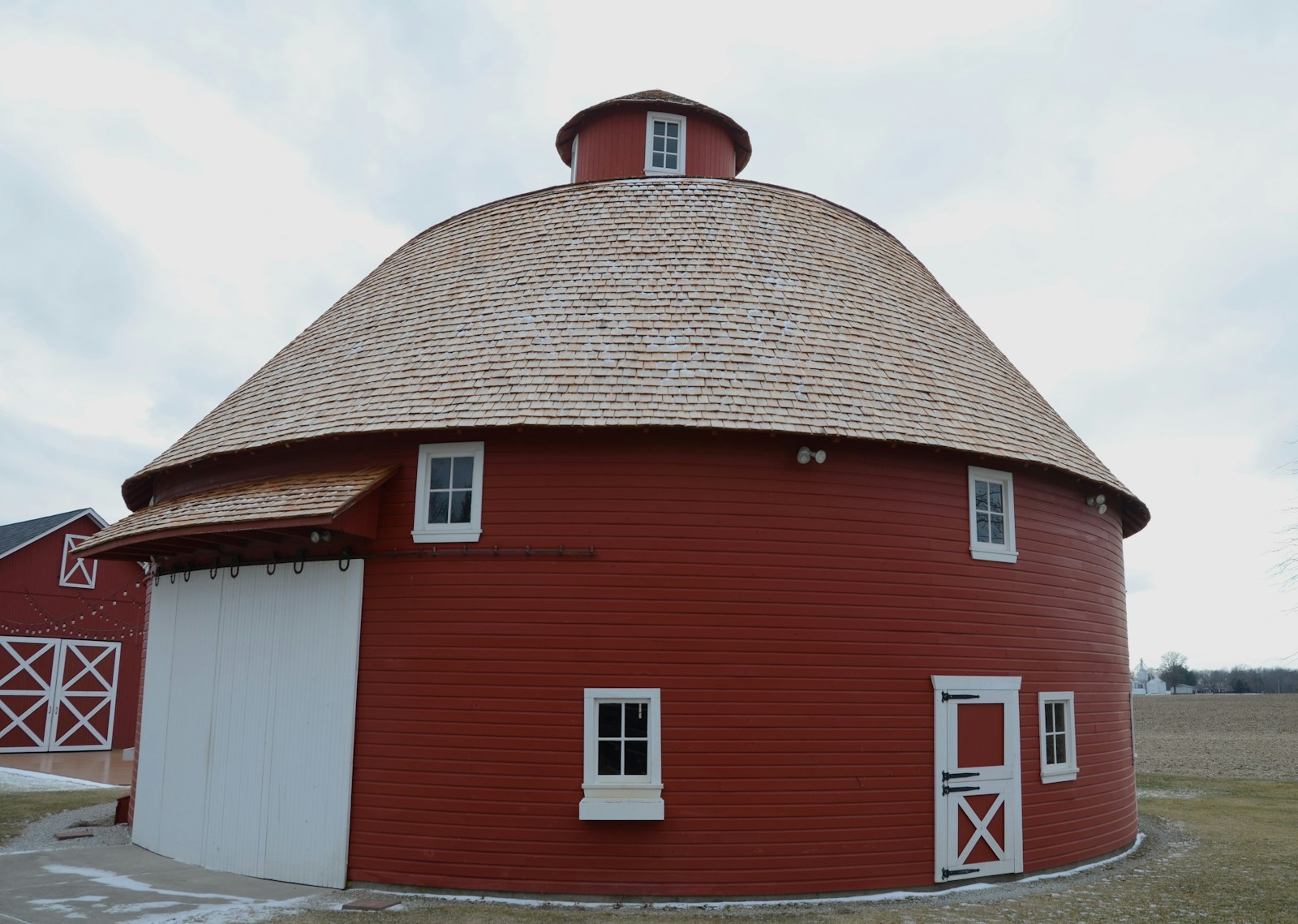 A large red round barn with a white door