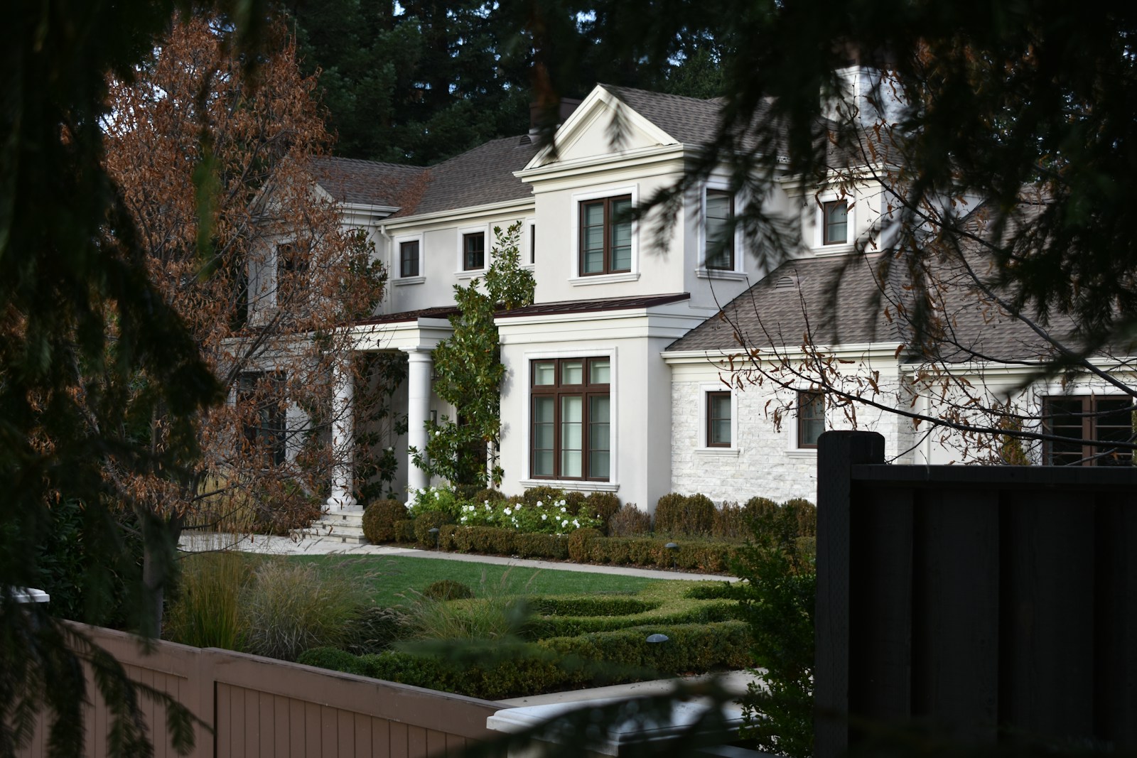 a large white house with a garden in front of it