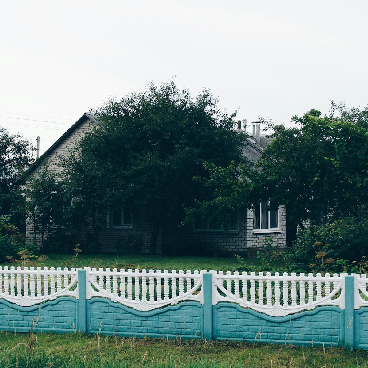 A house behind a decorative blue and white fence
