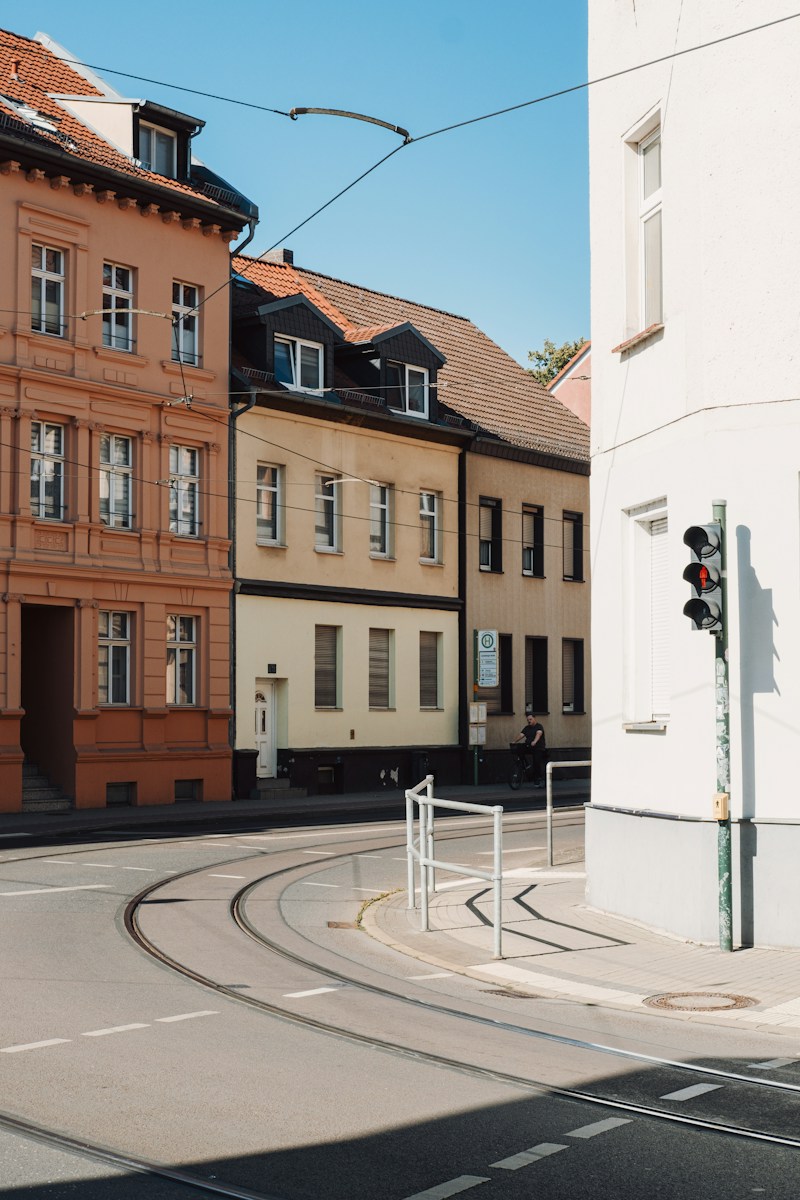 A person cycling past colorful buildings and tram tracks in Brandenburg, Germany