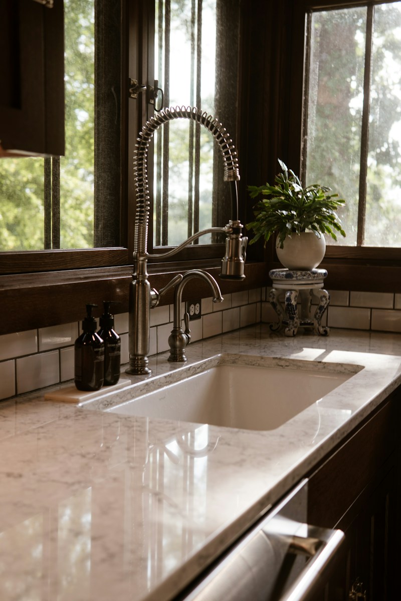 A kitchen sink sitting under a window next to a window