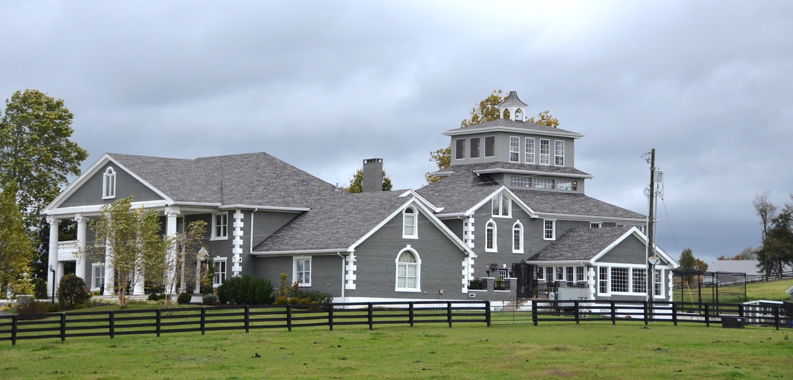 Large gray house with white trim and columns